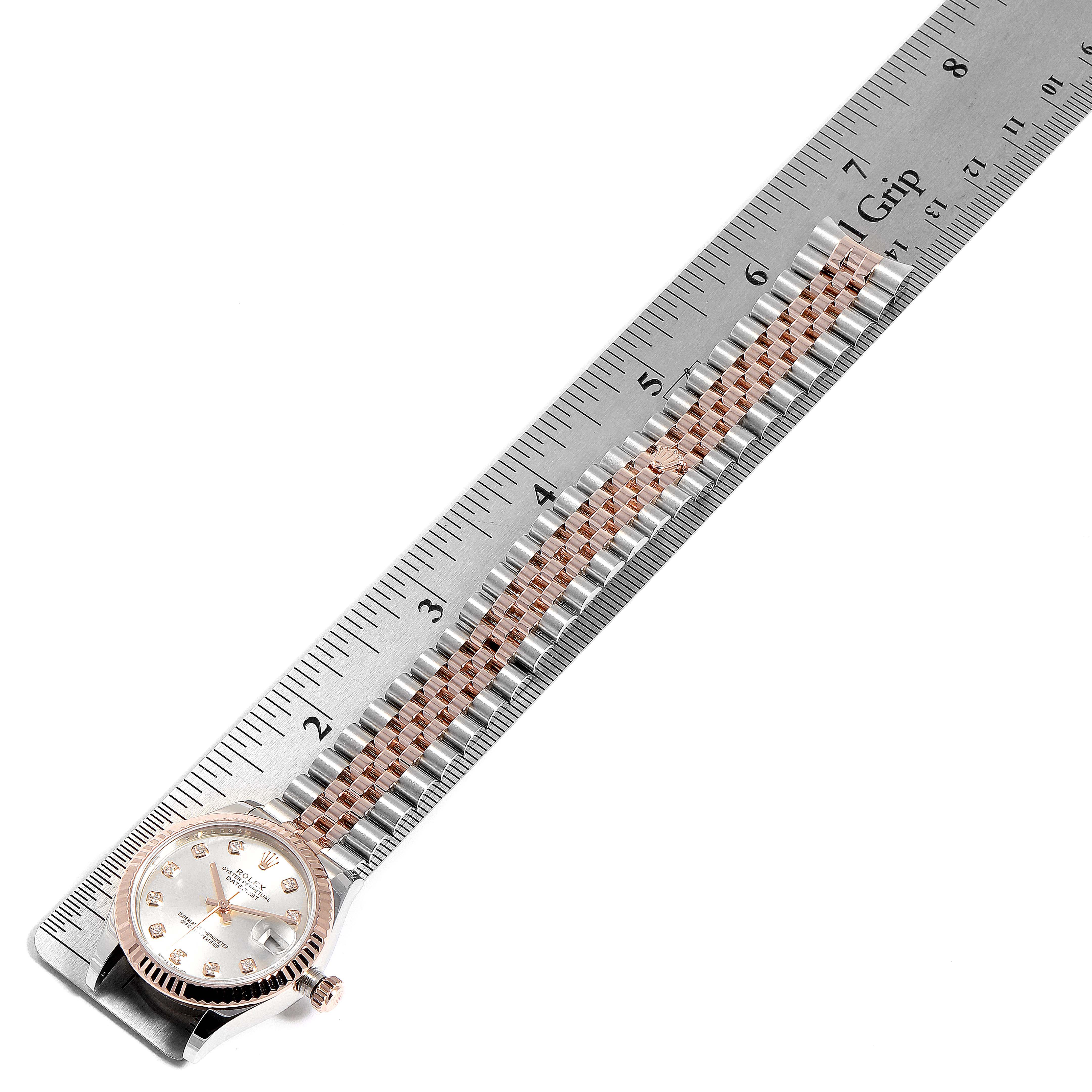 The image shows a Rolex Mid-Size 278271 Women
s Rose Gold Silver Dial 278271 Women
s Rose Gold Silver Dial watch with its bracelet placed on a ruler for measurement.