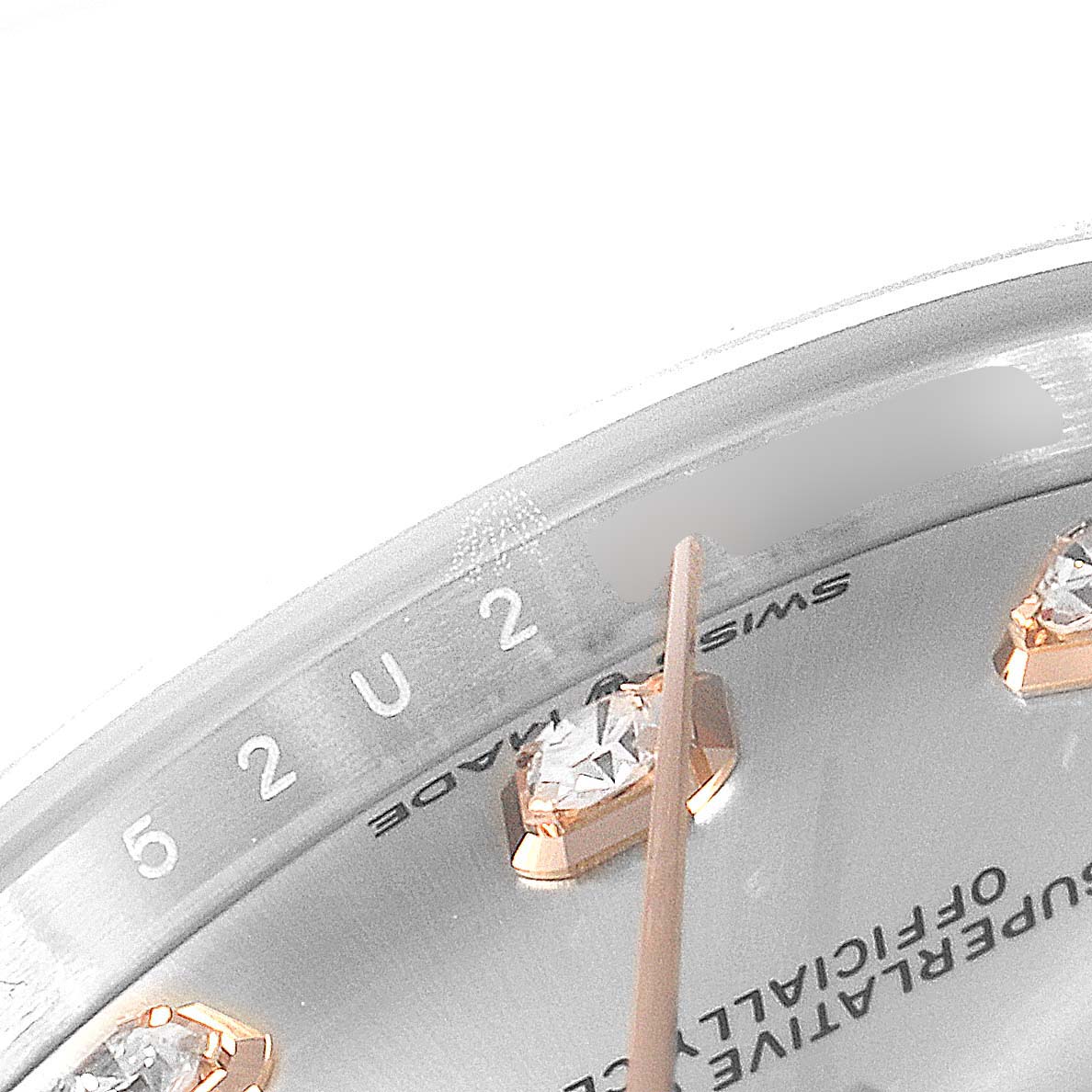 This close-up image shows the dial
s edge and diamond hour markers of a Mid-Size Rolex watch.
