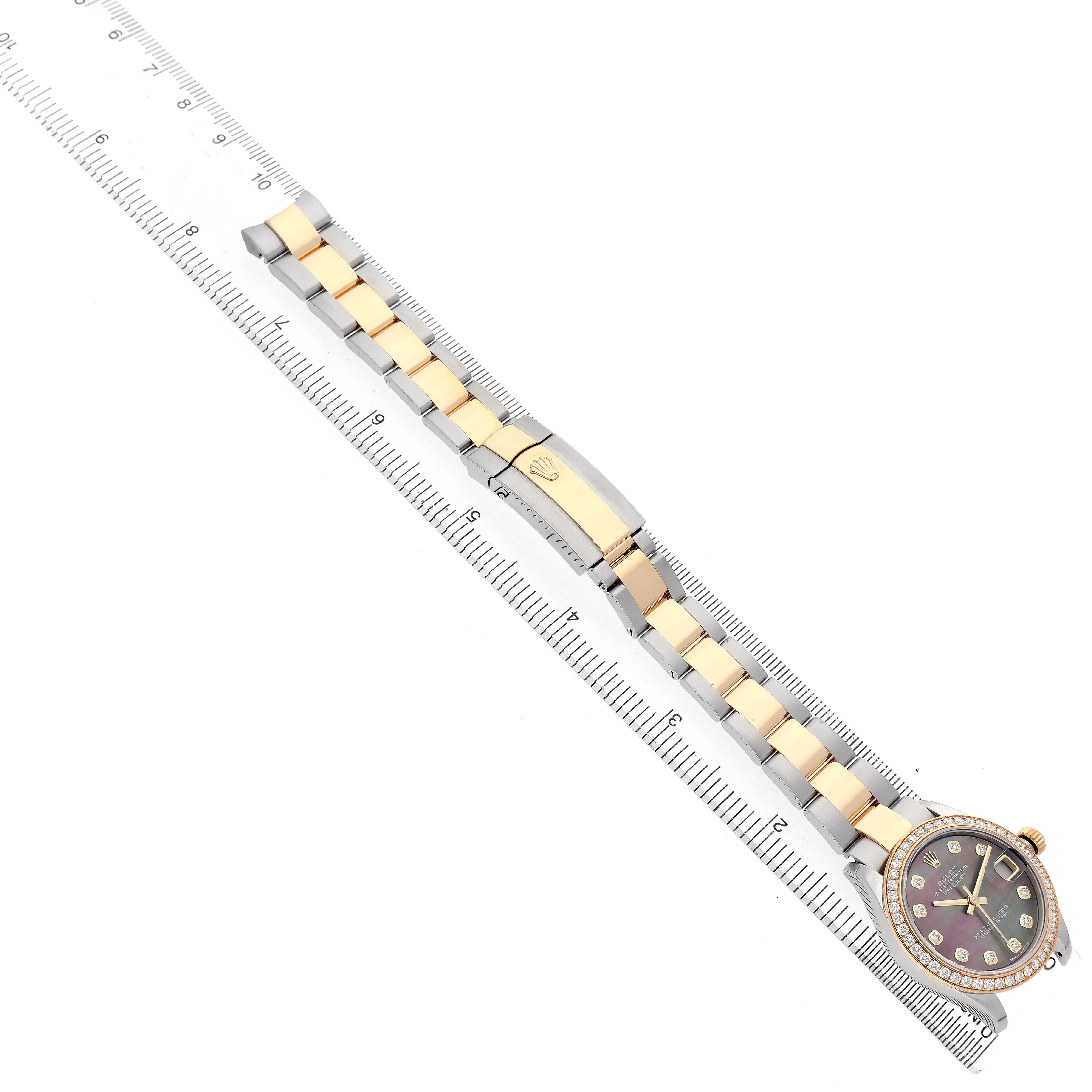 The Rolex Mid-Size 278383 Women's Steel and Gold (two tone) Mother of Pearl Dial model is shown from a top-down view, displaying the face, bezel, and full bracelet alongside a ruler for scale.