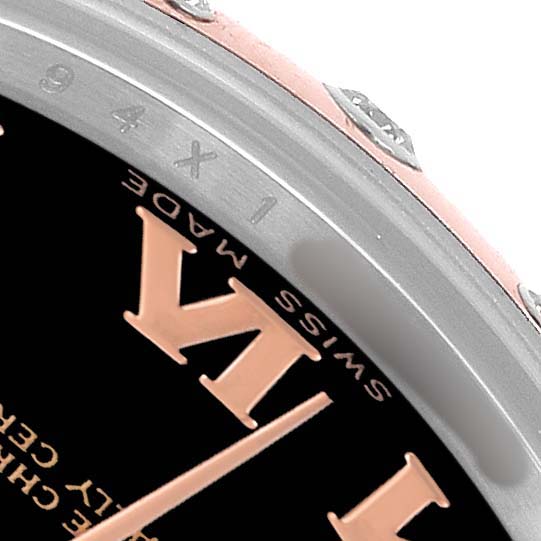 The image shows a close-up of the bezel and dial edge of a Rolex Datejust 178341 Women's Steel and Gold (two tone) Black Dial, highlighting part of the Roman numeral and bezel screws.