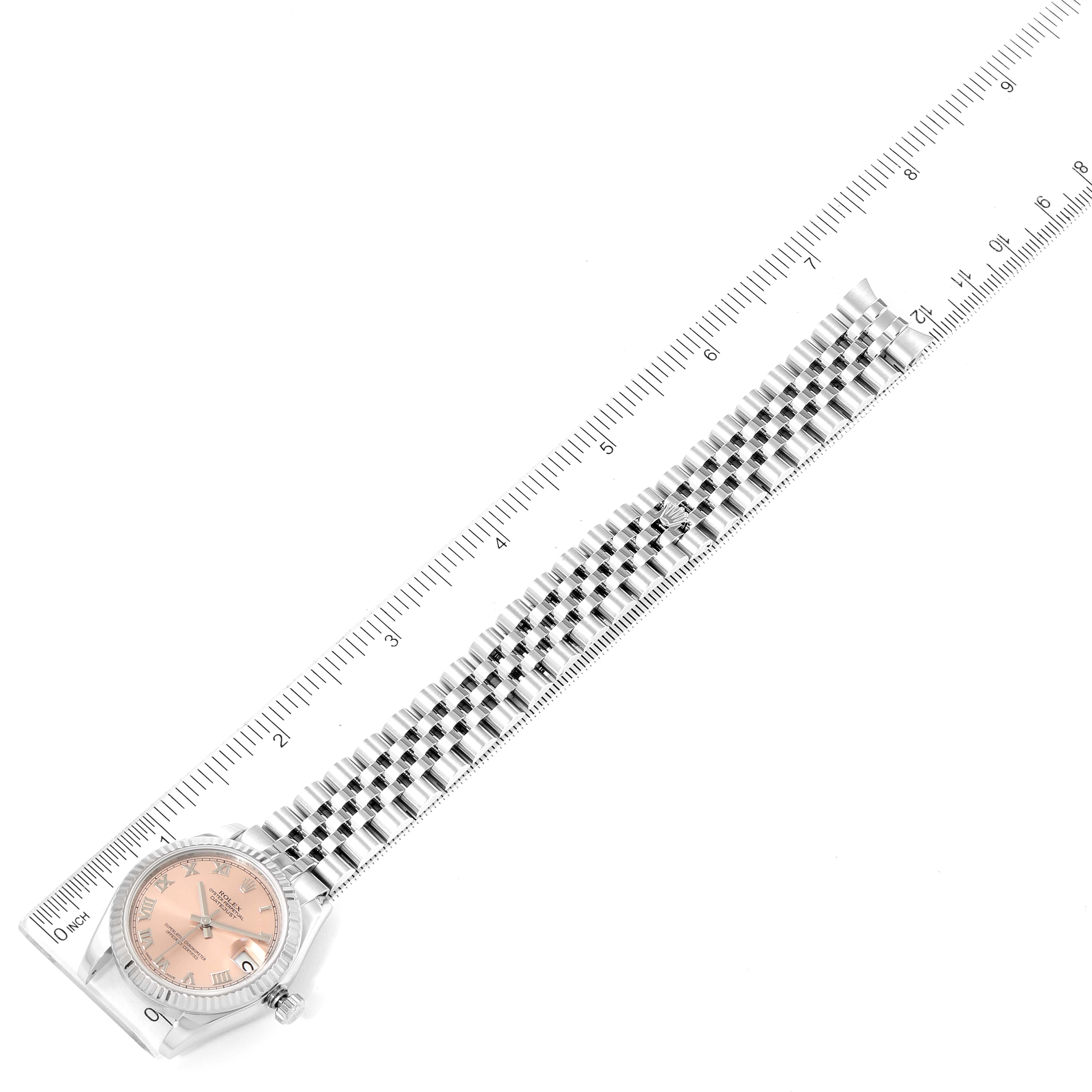 The Rolex Mid-Size 178274 Women's Stainless Steel Pink Dial 178274 Women's Stainless Steel Pink Dial watch is shown from an angled top-down perspective, illustrating its face and full bracelet length against a ruler.