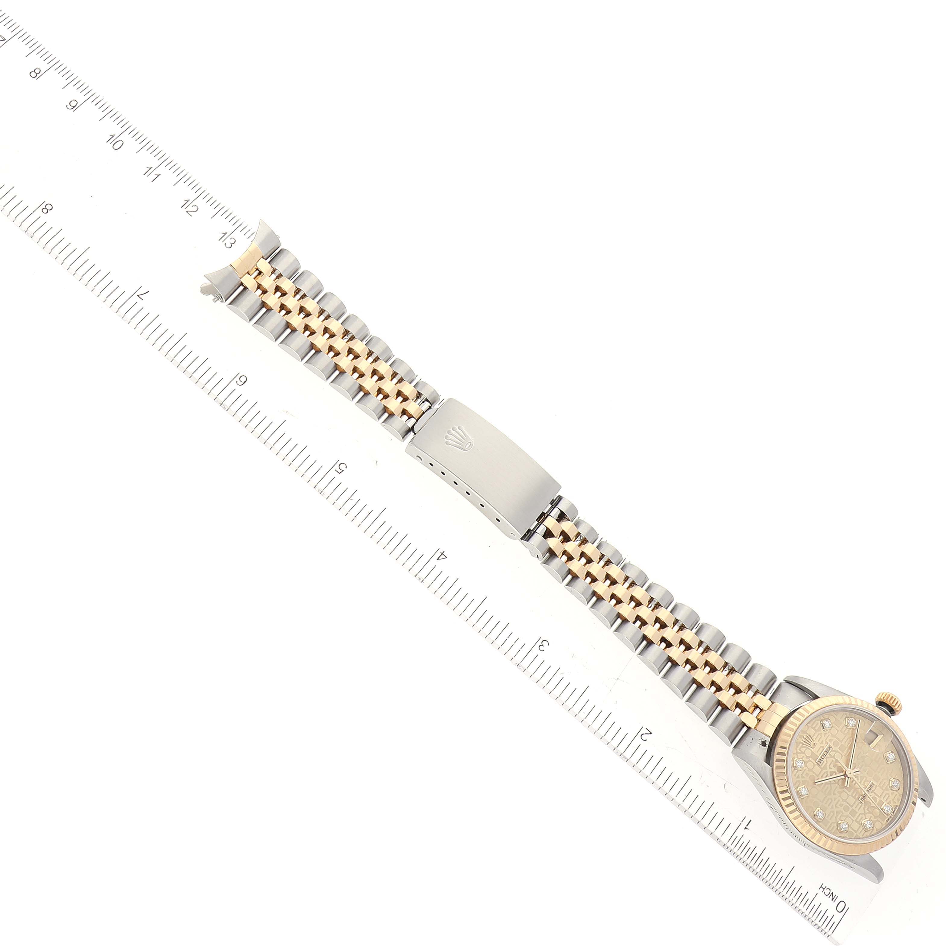 The image shows a Rolex Mid-Size 78273 Women
s Steel and Gold (two tone) Champagne Dial 78273 Women
s Steel and Gold (two tone) Champagne Dial model watch with a ruler for scale, showcasing the face, clasp, and two-tone bracelet.
