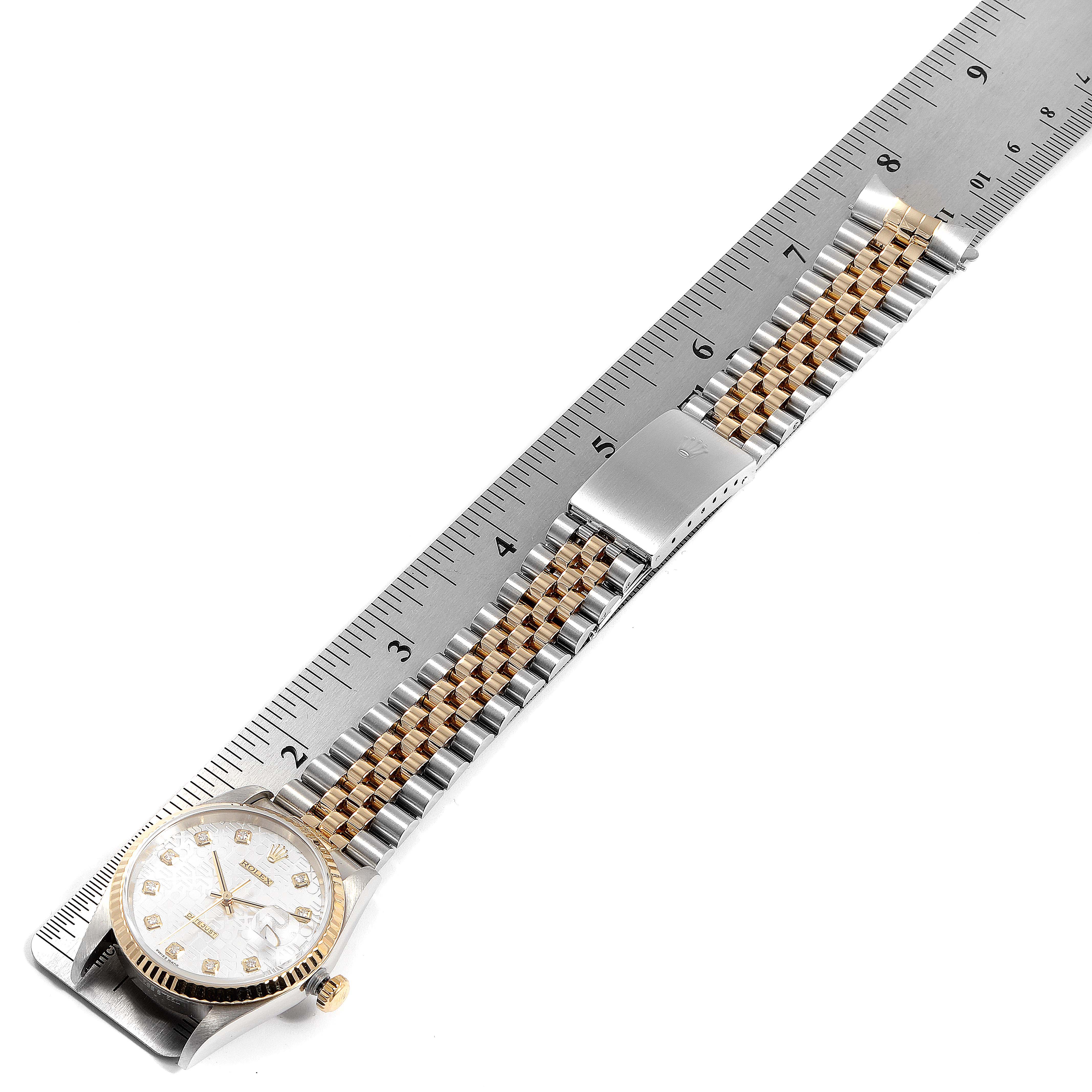 The Rolex Datejust 16233 Men
s Steel and Gold (two tone) Silver Dial 16233 Men
s Steel and Gold (two tone) Silver Dial watch is shown fully extended alongside a ruler, displaying the face, bracelet, and clasp.