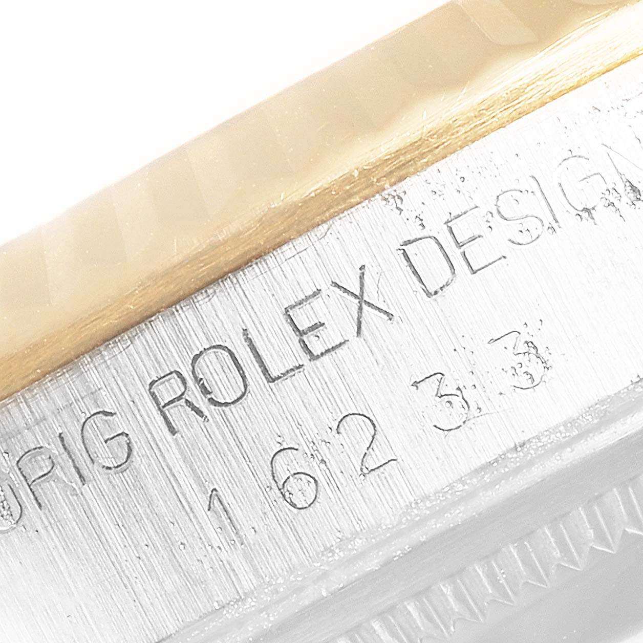 This image shows a close-up of the engraved details on the side of a Rolex Datejust 16233 Men
s Steel and Gold (two tone) Champagne Dial 16233 Men
s Steel and Gold (two tone) Champagne Dial watch case.