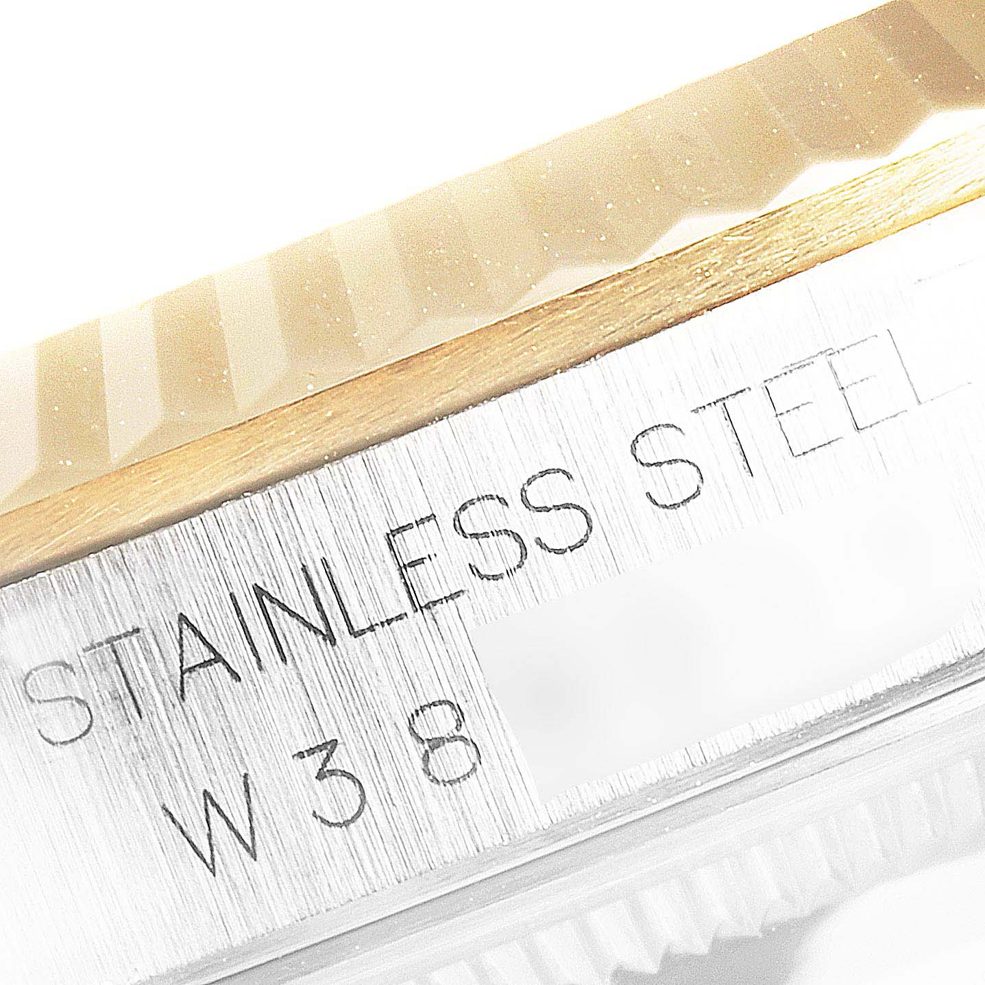 This image shows a close-up angle of the case side and a small part of the fluted bezel of a Rolex Datejust 16233 Men
s Steel and Gold (two tone) Champagne Dial 16233 Men
s Steel and Gold (two tone) Champagne Dial, with "STAINLESS STEEL" engraving.