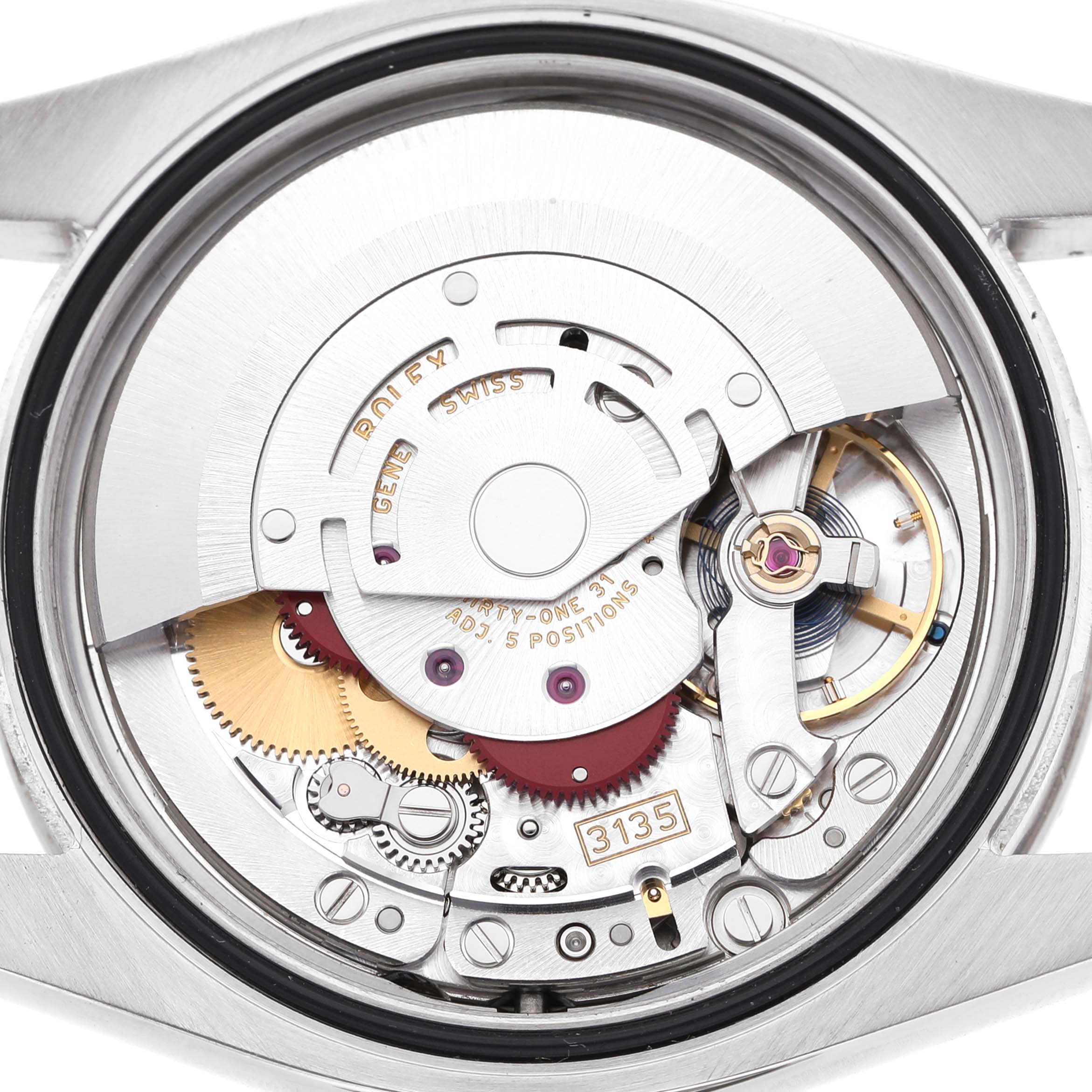The image shows the movement mechanism of a Rolex Datejust 116244 Men's Stainless Steel Silver Dial watch, viewed from the back, highlighting gears and rotor assembly.