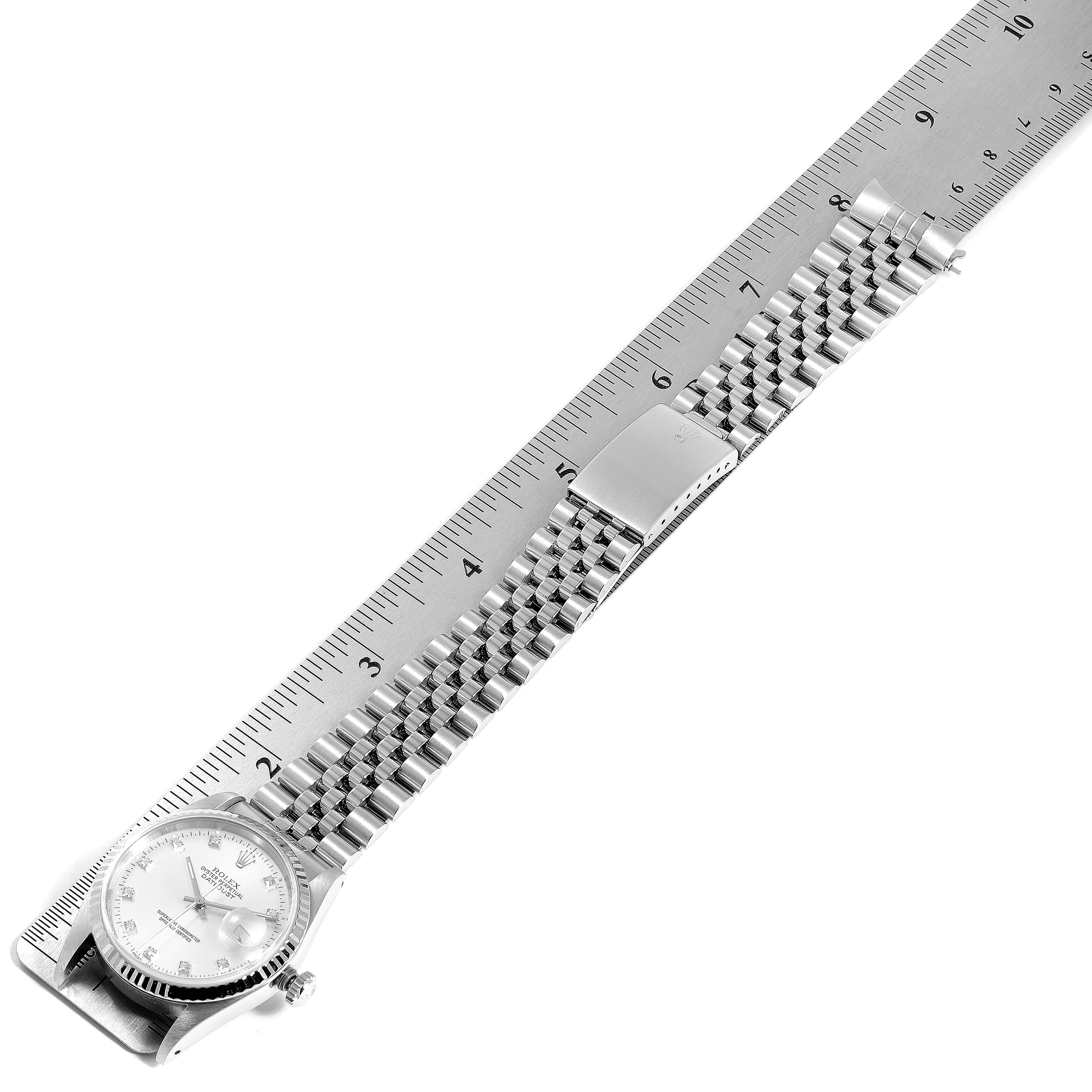 The image shows a Rolex Datejust 16234 Men's Stainless Steel Silver Dial 16234 Men's Stainless Steel Silver Dial watch laid out flat, alongside a ruler, displaying the face, bracelet, and clasp.