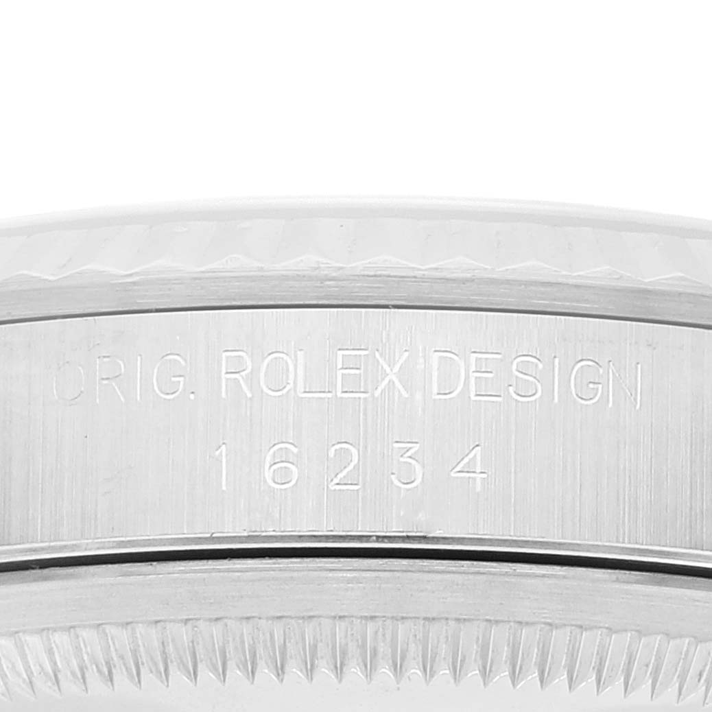 This image shows a close-up of the serial number and "ORIG. ROLEX DESIGN" engraving on the case of a Rolex Datejust 16234 Men's Stainless Steel Silver Dial 16234 Men's Stainless Steel Silver Dial model 16234.