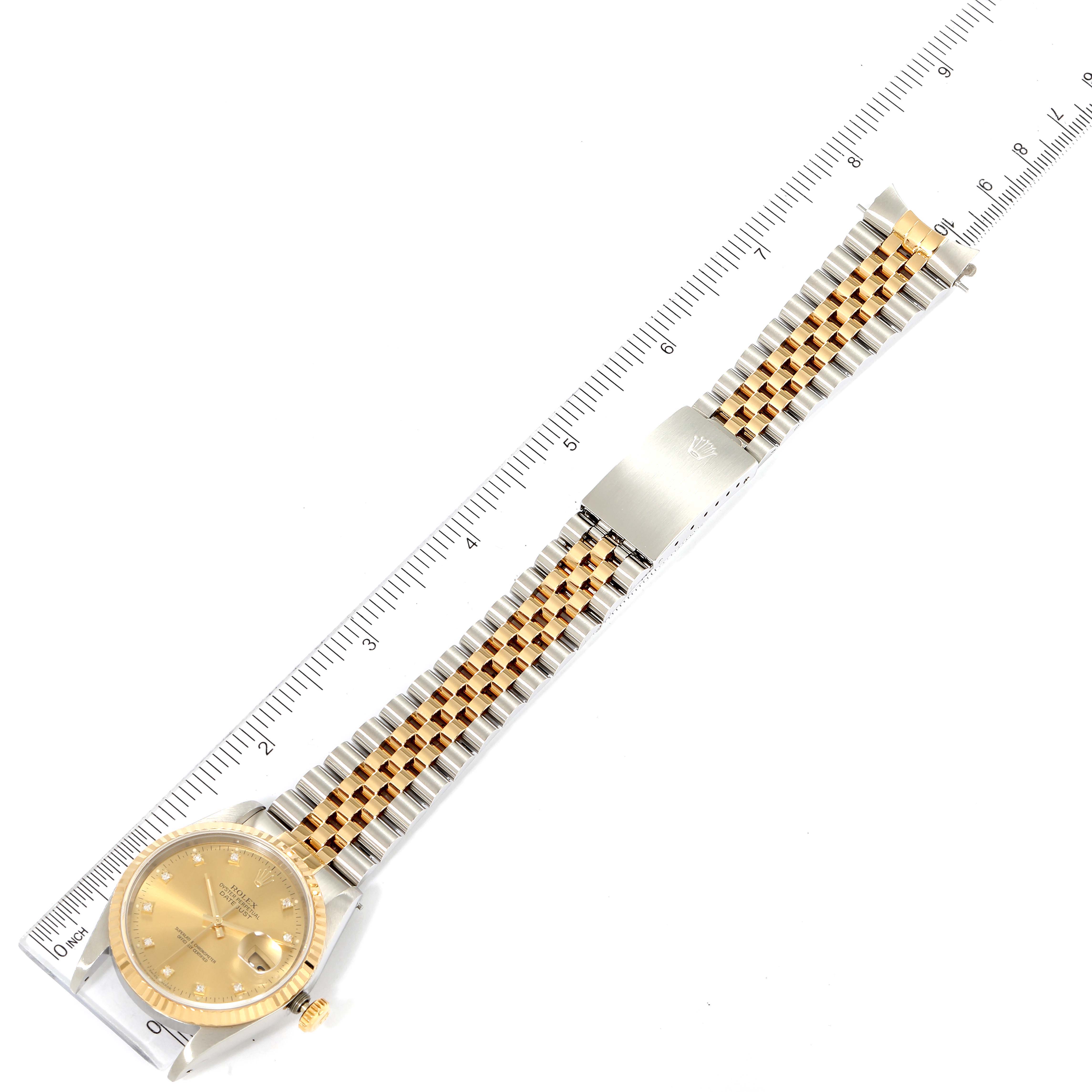 The image shows a top-down view of a Rolex Datejust 16233 Men's Steel and Gold (two tone) Champagne Dial 16233 Men's Steel and Gold (two tone) Champagne Dial watch, including the face, bezel, and two-tone bracelet with clasp laid next to a ruler.