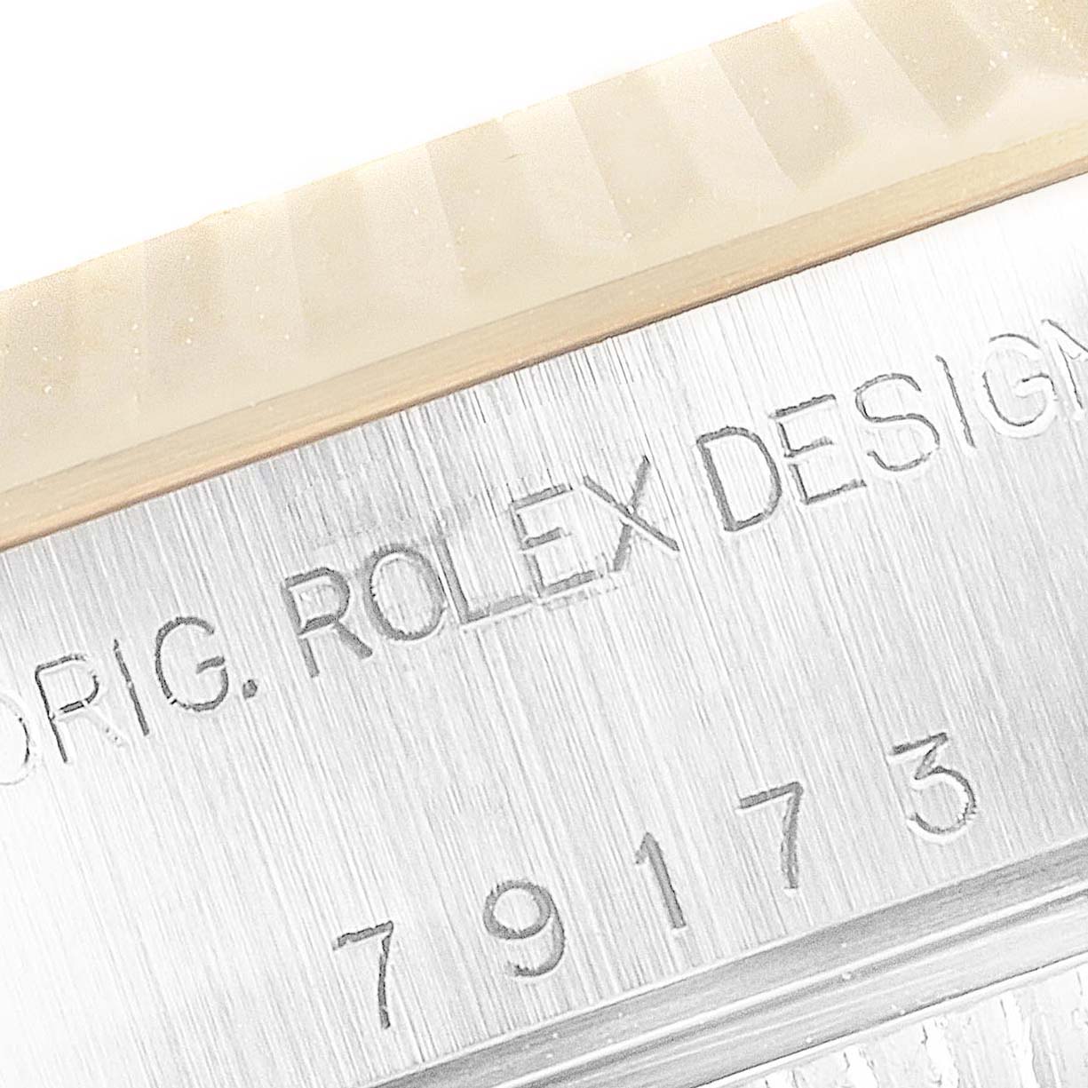 This close-up image shows the engraved serial number and "Rolex Design" text on the case of a Rolex Datejust 79173 Women's Steel and Gold (two tone) Silver Dial 79173 Women's Steel and Gold (two tone) Silver Dial watch.