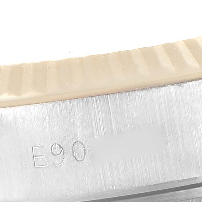 This close-up image shows the serial number and fluted bezel of a Rolex Datejust 69173 Women's Steel and Gold (two tone) White Dial 69173 Women's Steel and Gold (two tone) White Dial watch.