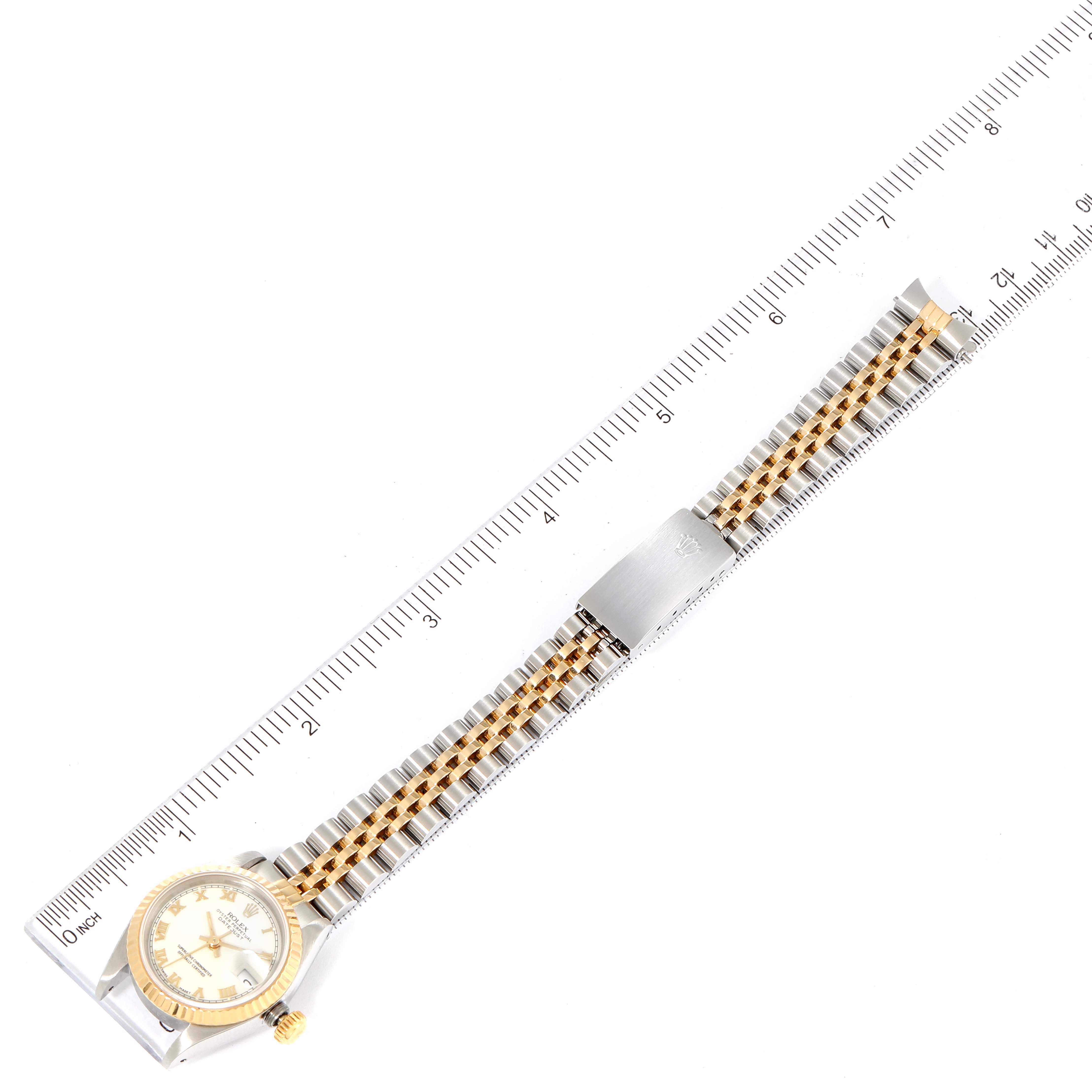 This image shows a Rolex Datejust 69173 Women's Steel and Gold (two tone) White Dial 69173 Women's Steel and Gold (two tone) White Dial watch laid flat with a ruler beside it, highlighting its face and metal bracelet.