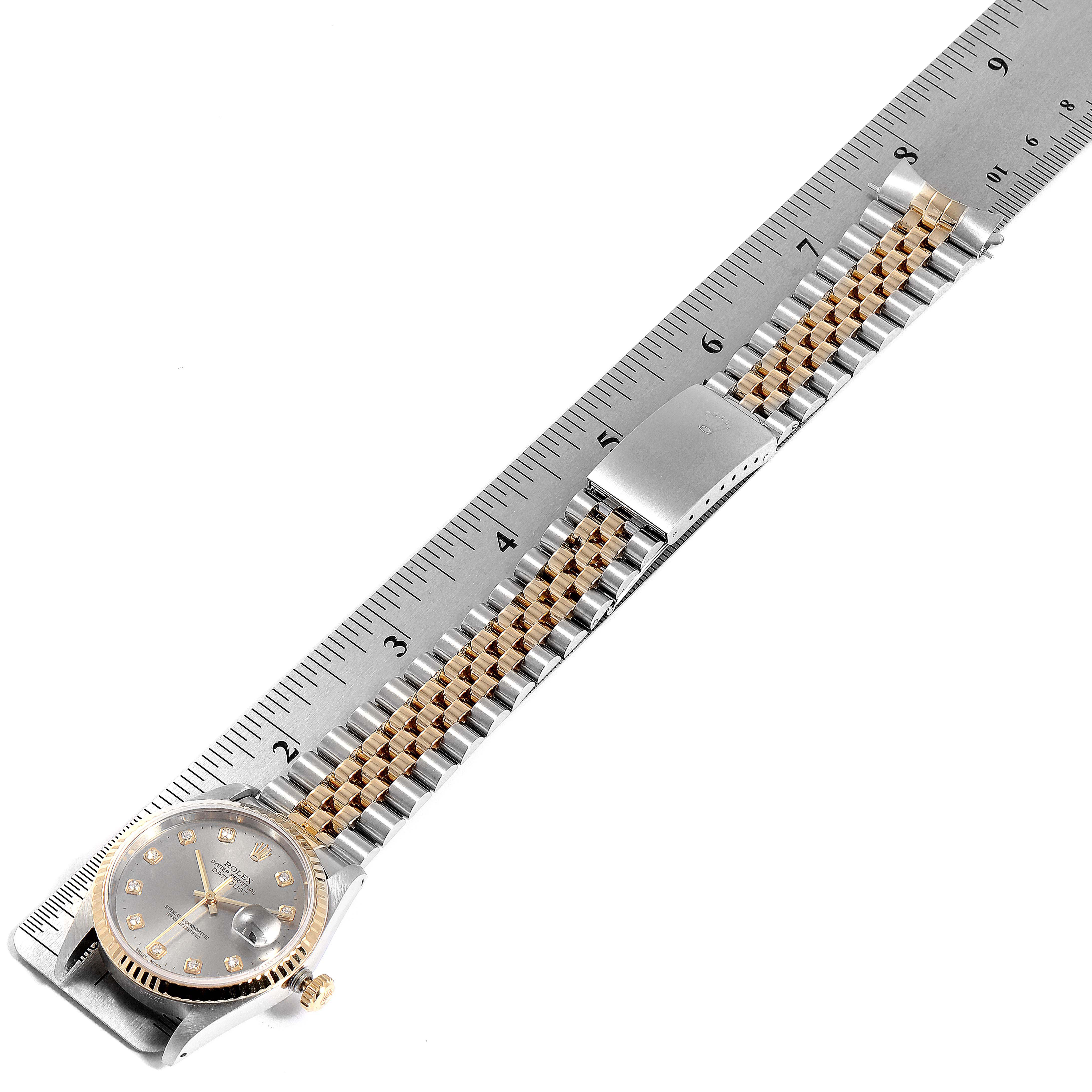 The Rolex Datejust 16233 Men
s Steel and Gold (two tone) Grey Dial 16233 Men
s Steel and Gold (two tone) Grey Dial is shown laying flat with its dial, jubilee bracelet, and clasp on display next to a ruler.