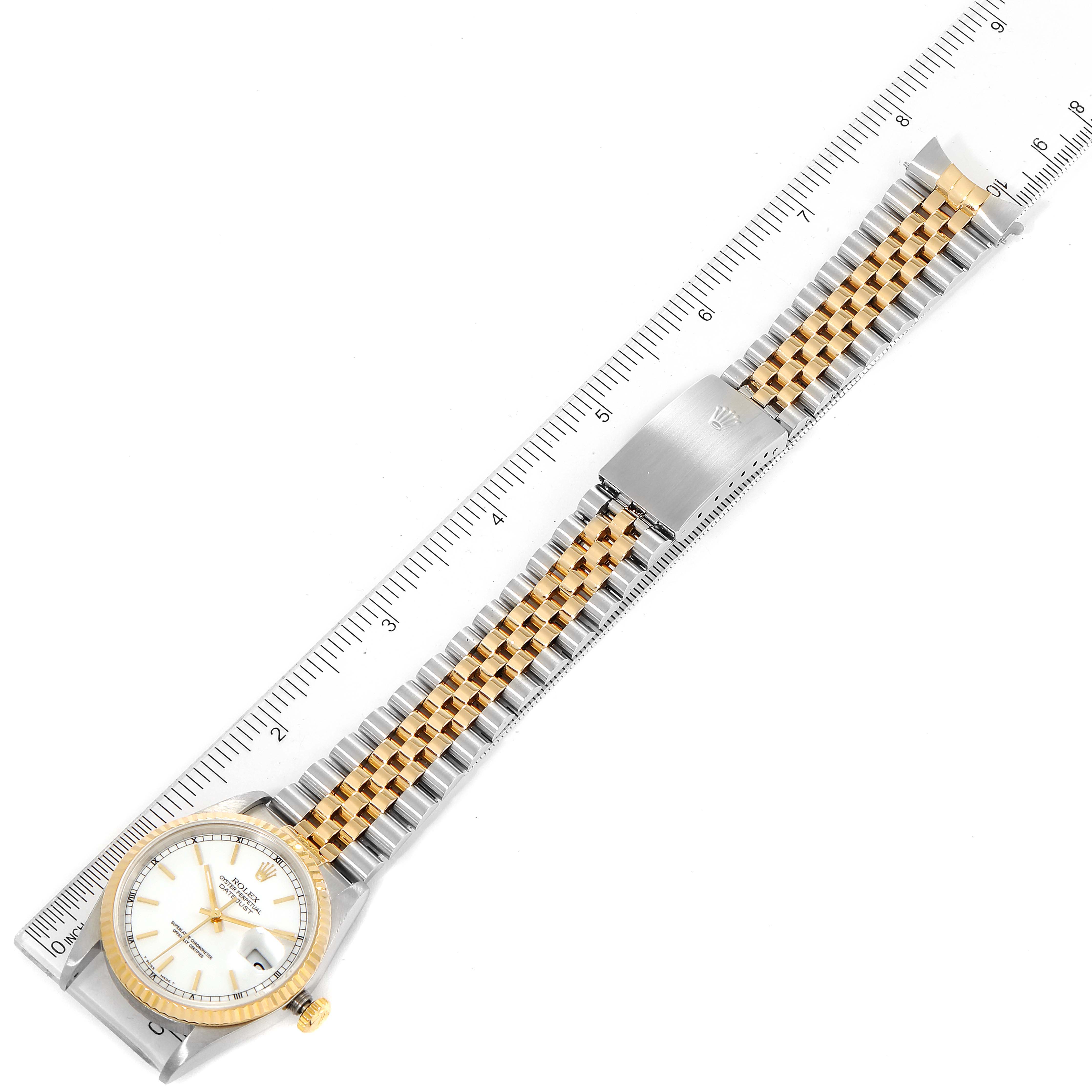 This image shows the Rolex Datejust 16233 Men's Steel and Gold (two tone) White Dial 16233 Men's Steel and Gold (two tone) White Dial watch laid flat from a top-down angle, including the watch face, bracelet, and ruler for scale.