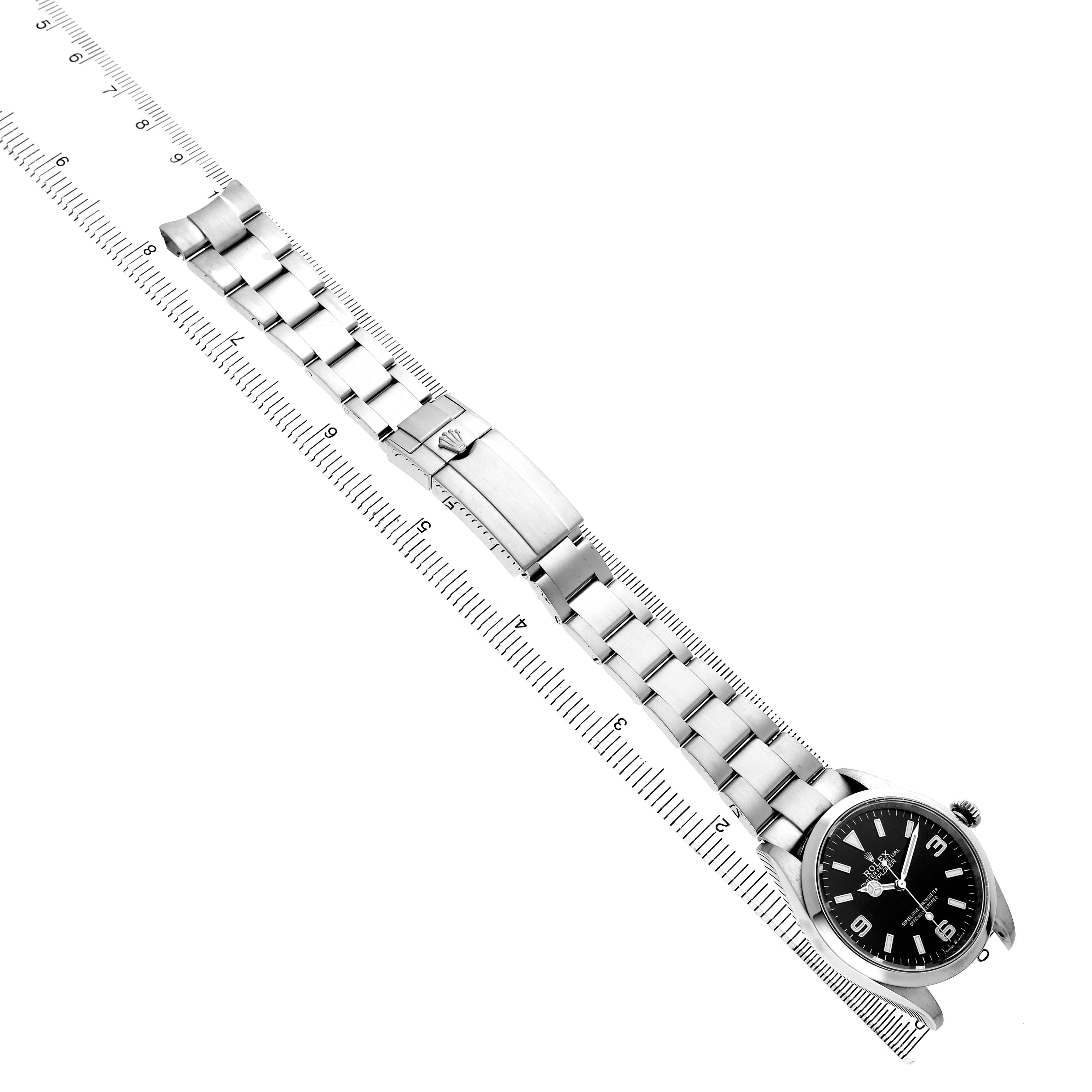 The Rolex Explorer 124270 Men's Stainless Steel Black Dial watch is shown at an angle displaying both the face and the bracelet alongside a ruler for scale.