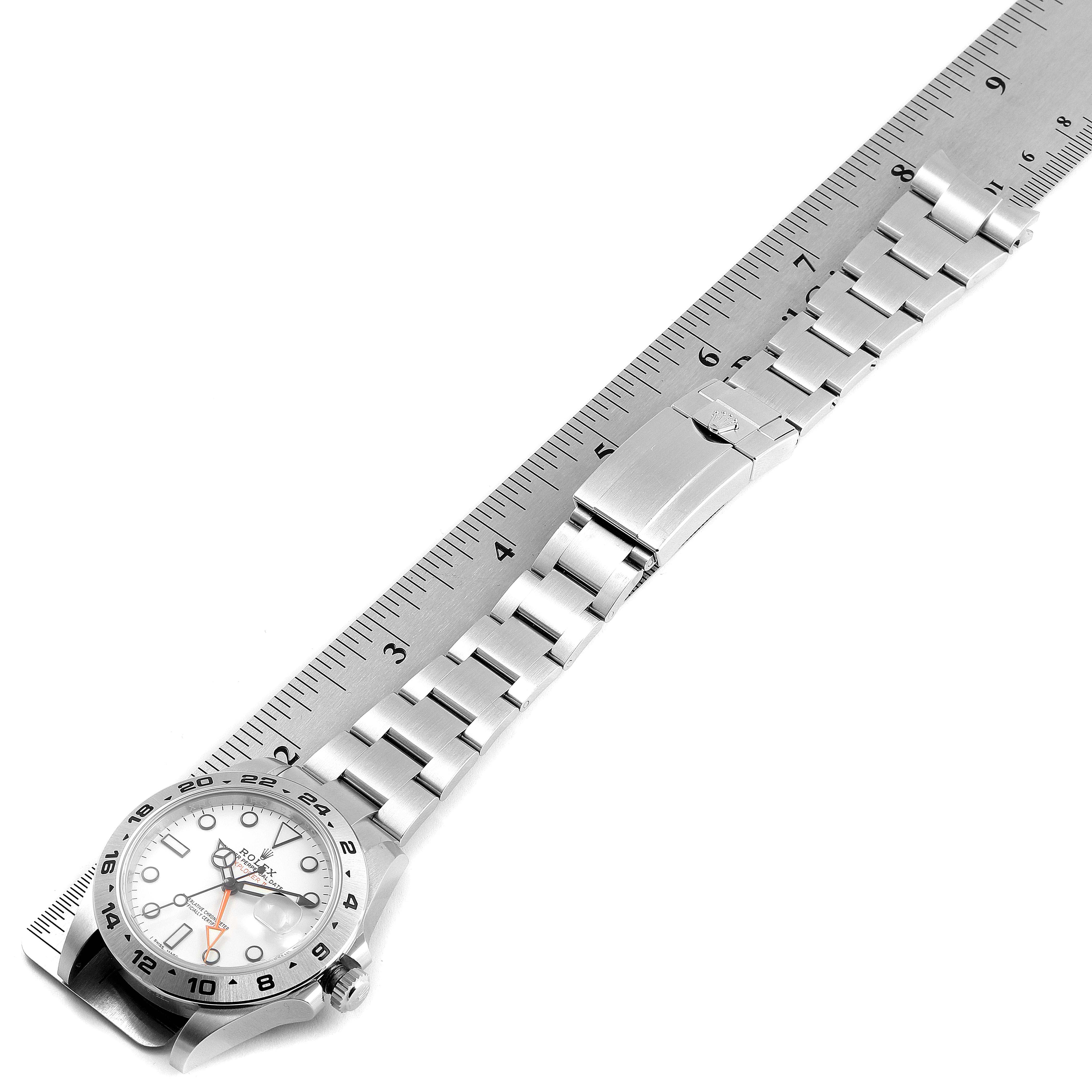 The Rolex Explorer 216570 Men
s Stainless Steel White Dial 216570 Men
s Stainless Steel White Dial model watch is displayed flat with the face and full metal bracelet visible, aligned with a ruler.