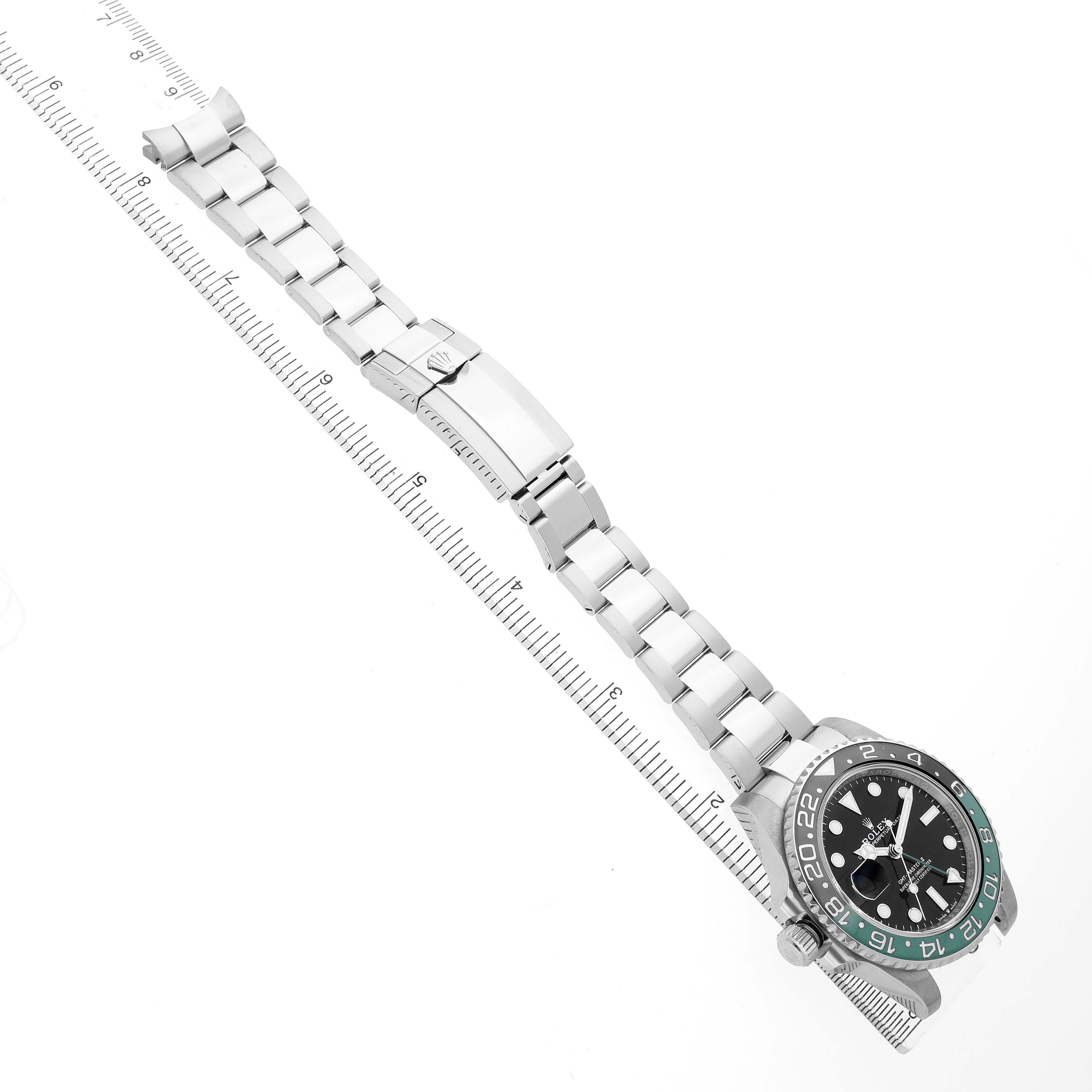 The Rolex GMT-Master 126720VTNR Men's Stainless Steel Black Dial watch is shown from a top-down angle, highlighting its full bracelet and bezel resting on a ruler.
