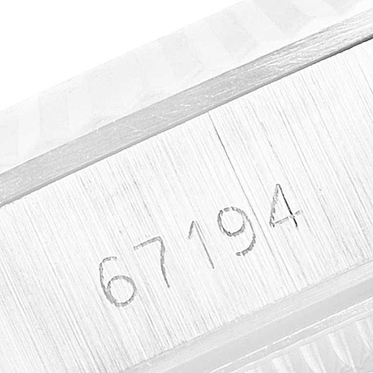 This close-up image shows the engraved serial number on the side of the case on a Rolex Oyster Perpetual 67194 Women's Stainless Steel Silver Dial 67194 Women's Stainless Steel Silver Dial watch.