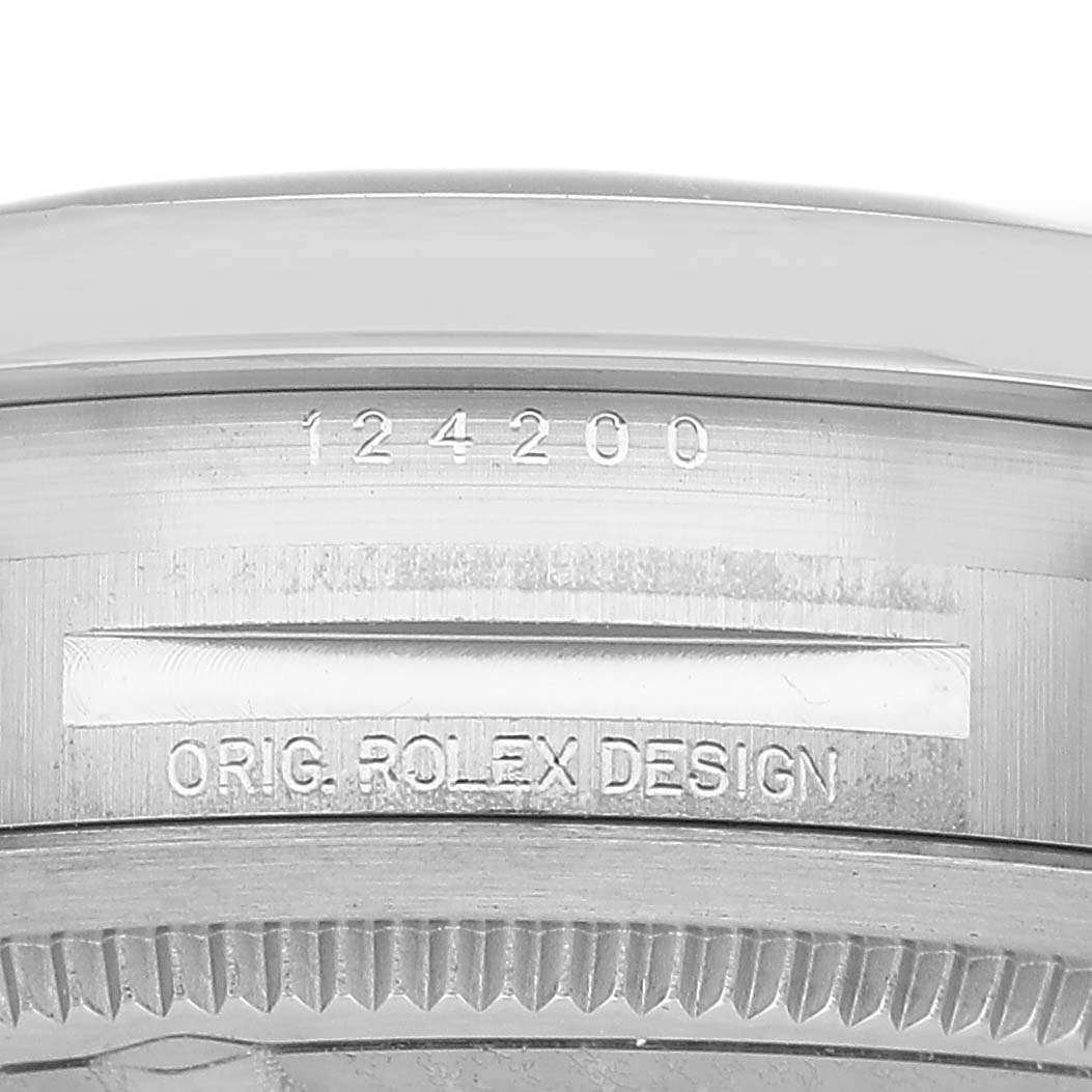 The image shows the side profile of a Rolex Oyster Perpetual 124200 Men's Stainless Steel Black Dial watch, focusing on the engraved serial number and text "ORIG. ROLEX DESIGN."
