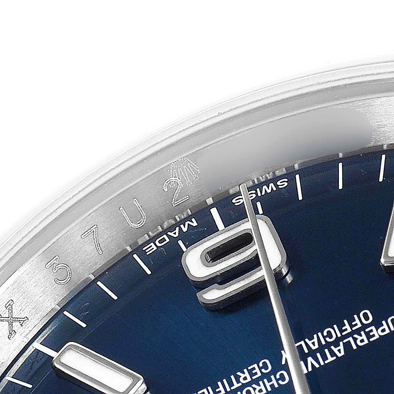 The image shows a close-up view of the dial and part of the bezel of a Rolex Oyster Perpetual 116000 Men's Stainless Steel Blue Dial 116000 Men's Stainless Steel Blue Dial watch.
