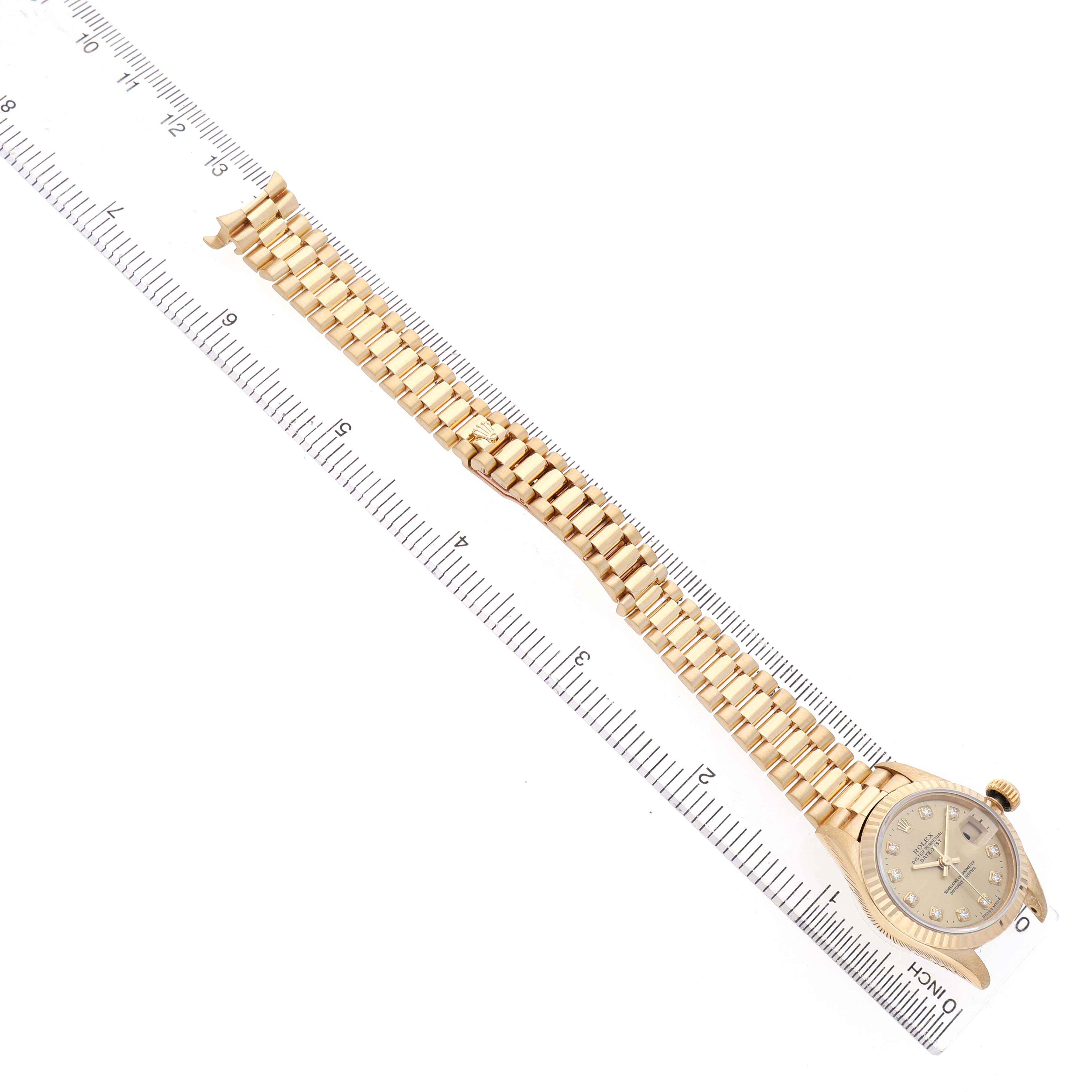 The Rolex President 69178 Women's Yellow Gold Champagne Dial watch is shown from a top-down angle, including the dial and full bracelet, next to a ruler for scale.