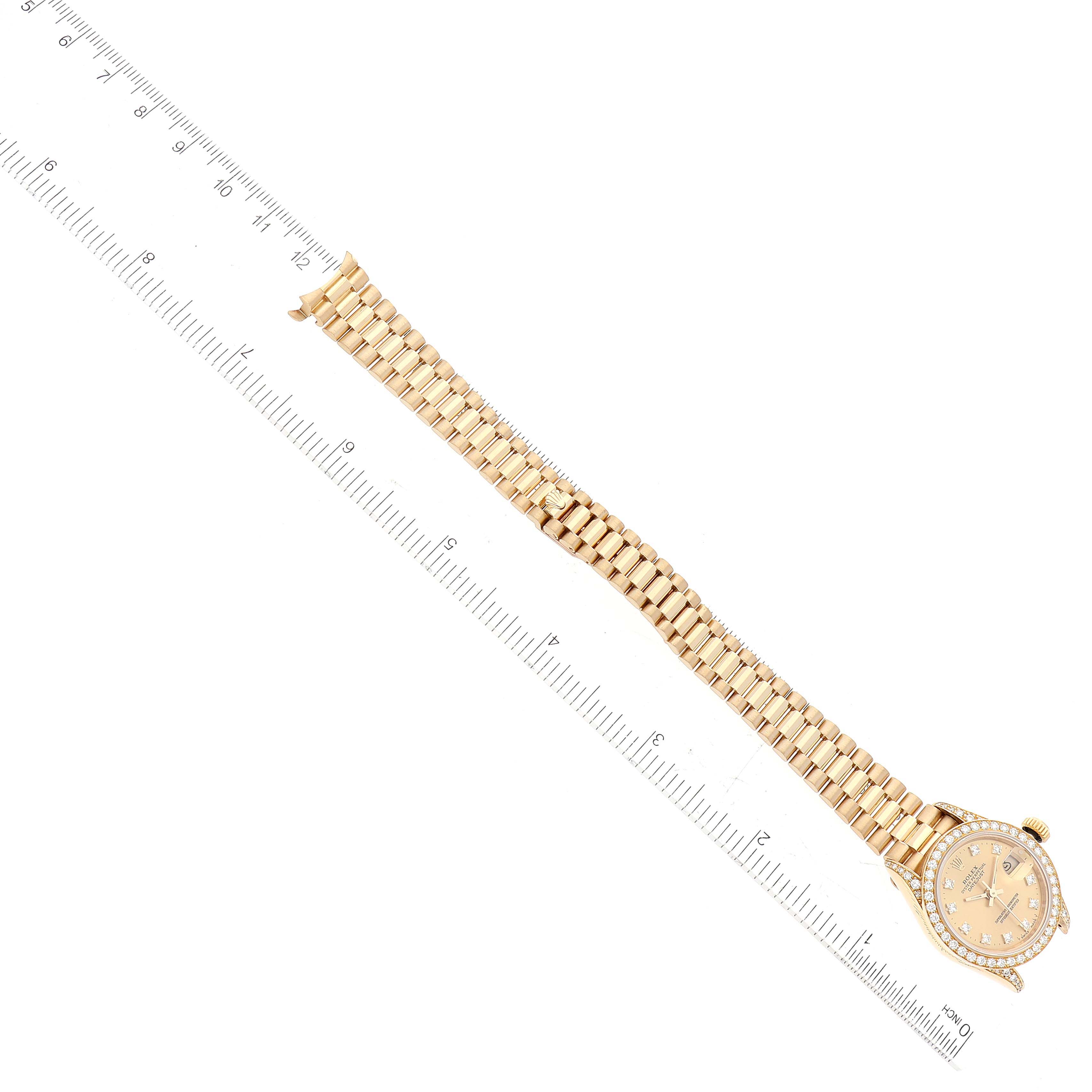 The Rolex President 69158 Women
s Yellow Gold Champagne Dial 69158 Women
s Yellow Gold Champagne Dial model watch is shown fully extended, laid flat, and angled diagonally with a ruler for scale.