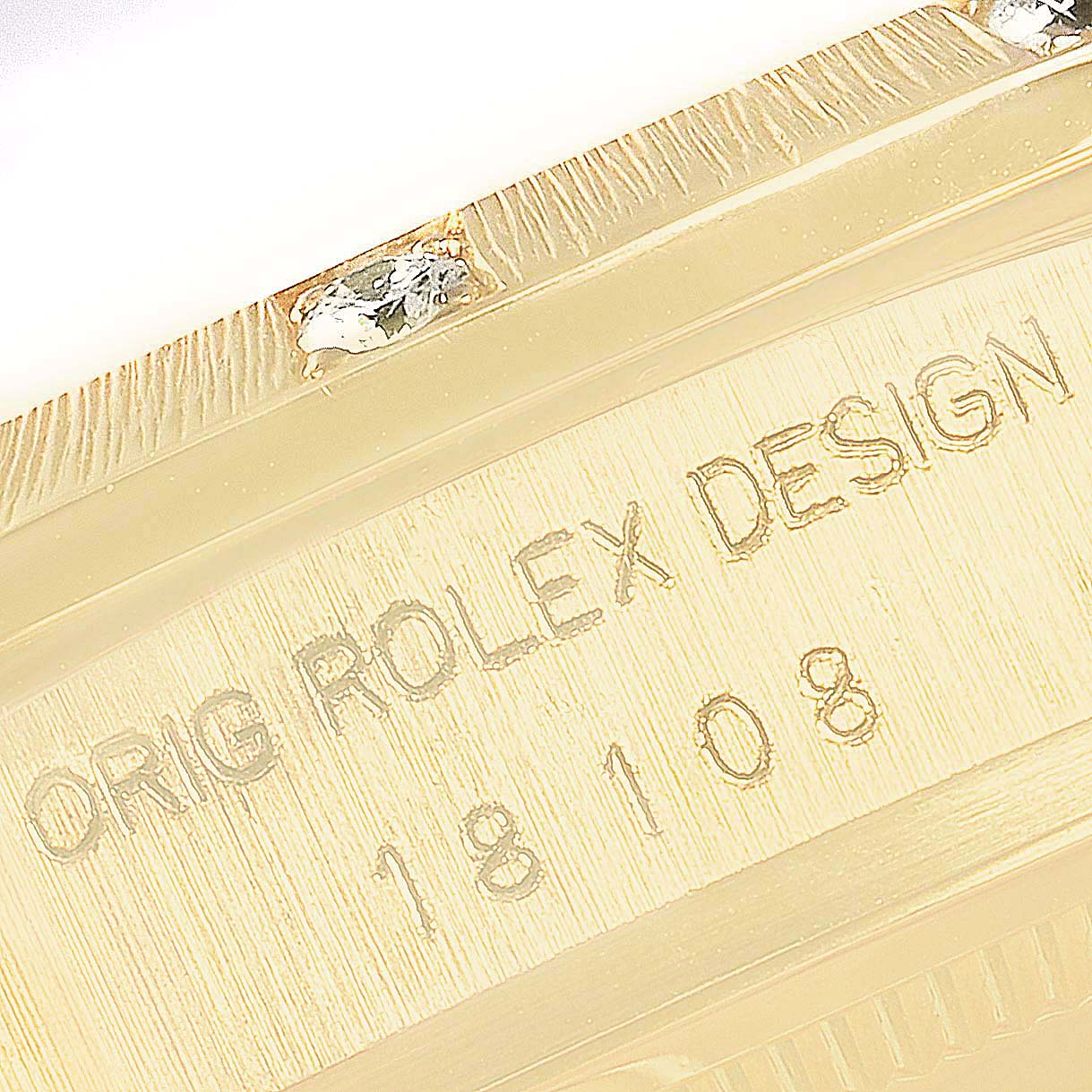 This image shows a close-up angle of the engraved side of a Rolex President 18108 Men
s Yellow Gold Champagne Dial 18108 Men
s Yellow Gold Champagne Dial model watch, displaying the text "ORIG ROLEX DESIGN 18108."
