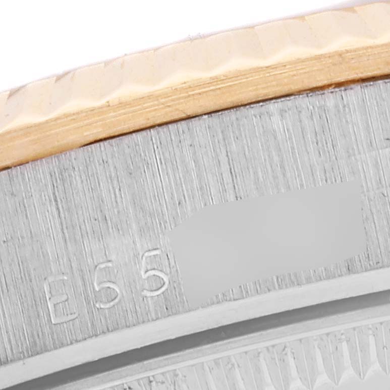 This image shows a close-up of the Rolex President 68279 Women
s Steel and Gold (two tone) Champagne Dial 68279 Women
s Steel and Gold (two tone) Champagne Dial watch, focusing on the edge of the bezel and part of the case with an engraved number.