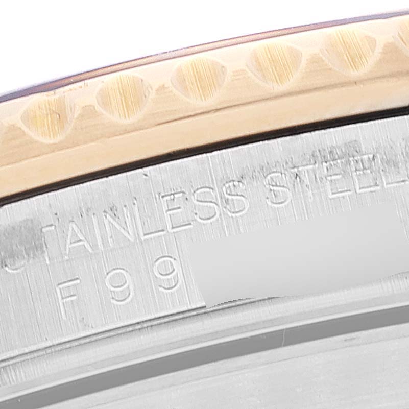 This close-up image shows the bezel and part of the case back of a Rolex Submariner 16613 Men
s Steel and Gold (two tone) Blue Dial 16613 Men
s Steel and Gold (two tone) Blue Dial watch, with text indicating stainless steel.