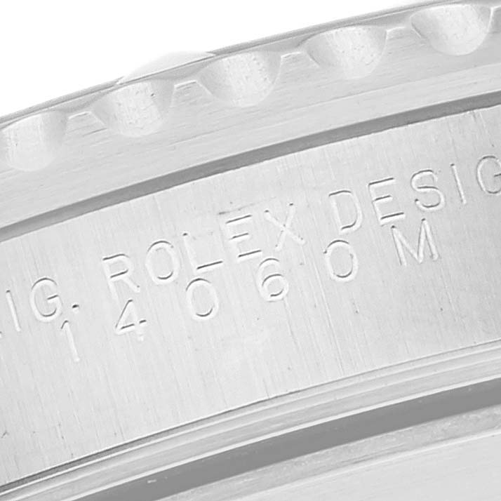 The image shows a close-up of the case side with engraving of a Rolex Submariner 14060M Men
s Stainless Steel Black Dial 14060M Men
s Stainless Steel Black Dial watch, focusing on the model number and design inscription.