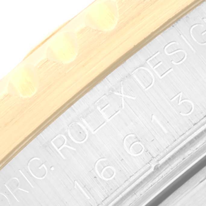 Close-up angle of a Rolex Submariner 16613 Men
s Steel and Gold (two tone) Black Dial 16613 Men
s Steel and Gold (two tone) Black Dial showing the engraved model number and part of the bezel.