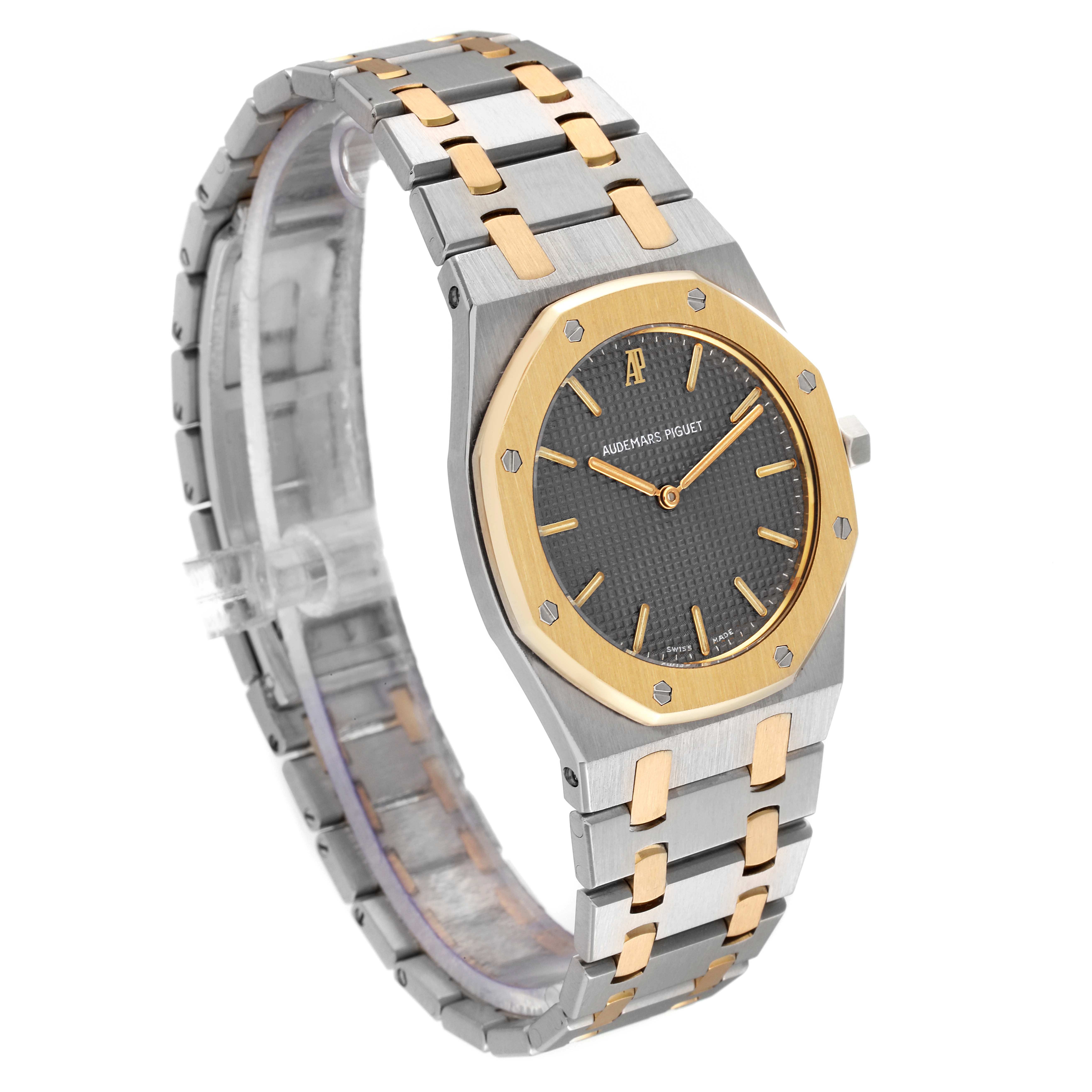 The image shows a front-side angle of the Audemars Piguet Royal Oak 56303SA Men
s Steel and Gold (two tone) Grey Dial 56303SA Men
s Steel and Gold (two tone) Grey Dial watch, highlighting its bezel, dial, and bracelet.