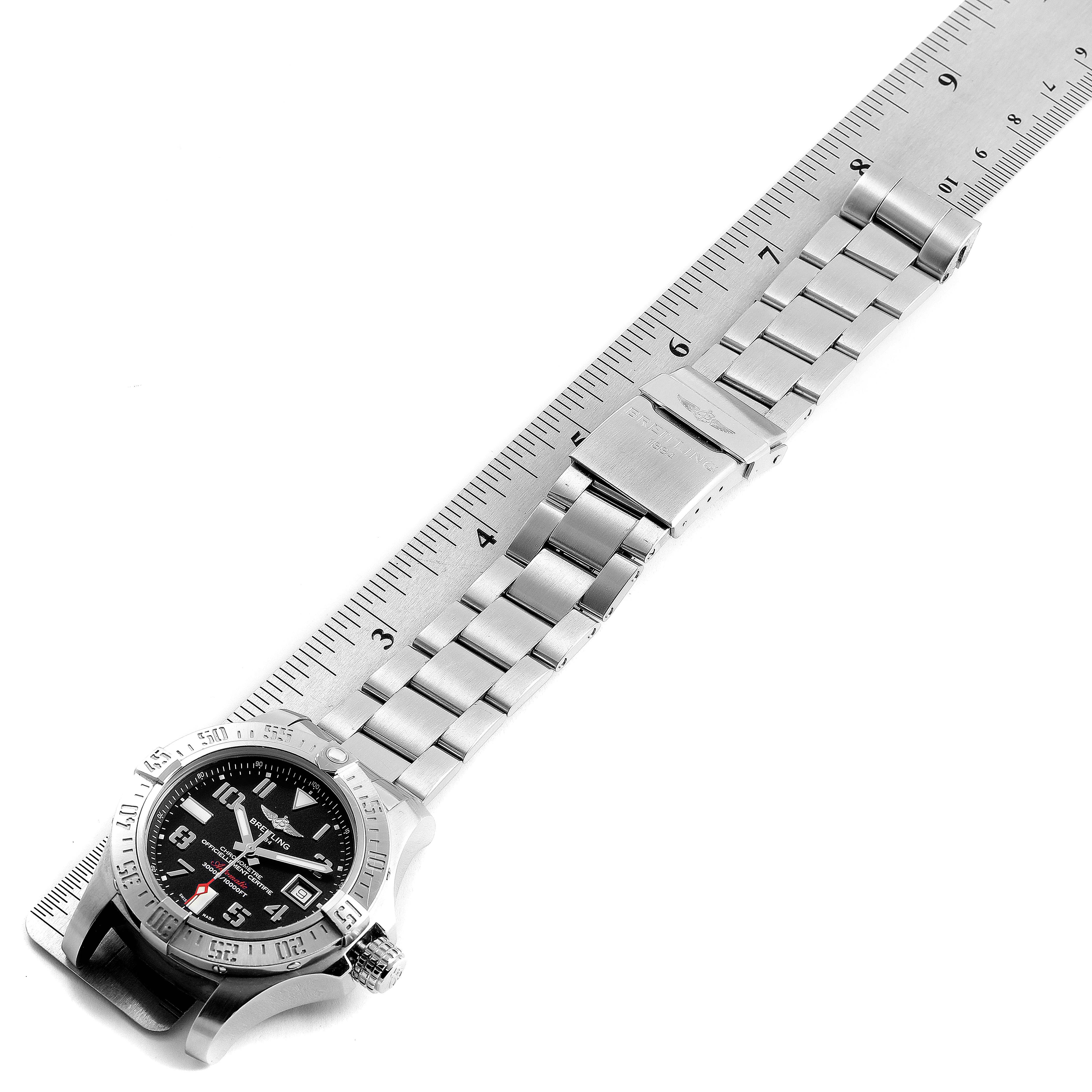 The image shows the Breitling Avenger A17331 Men's Stainless Steel Black Dial A17331 Men's Stainless Steel Black Dial watch from an overhead angle, including the face, bezel, and metal bracelet against a ruler.