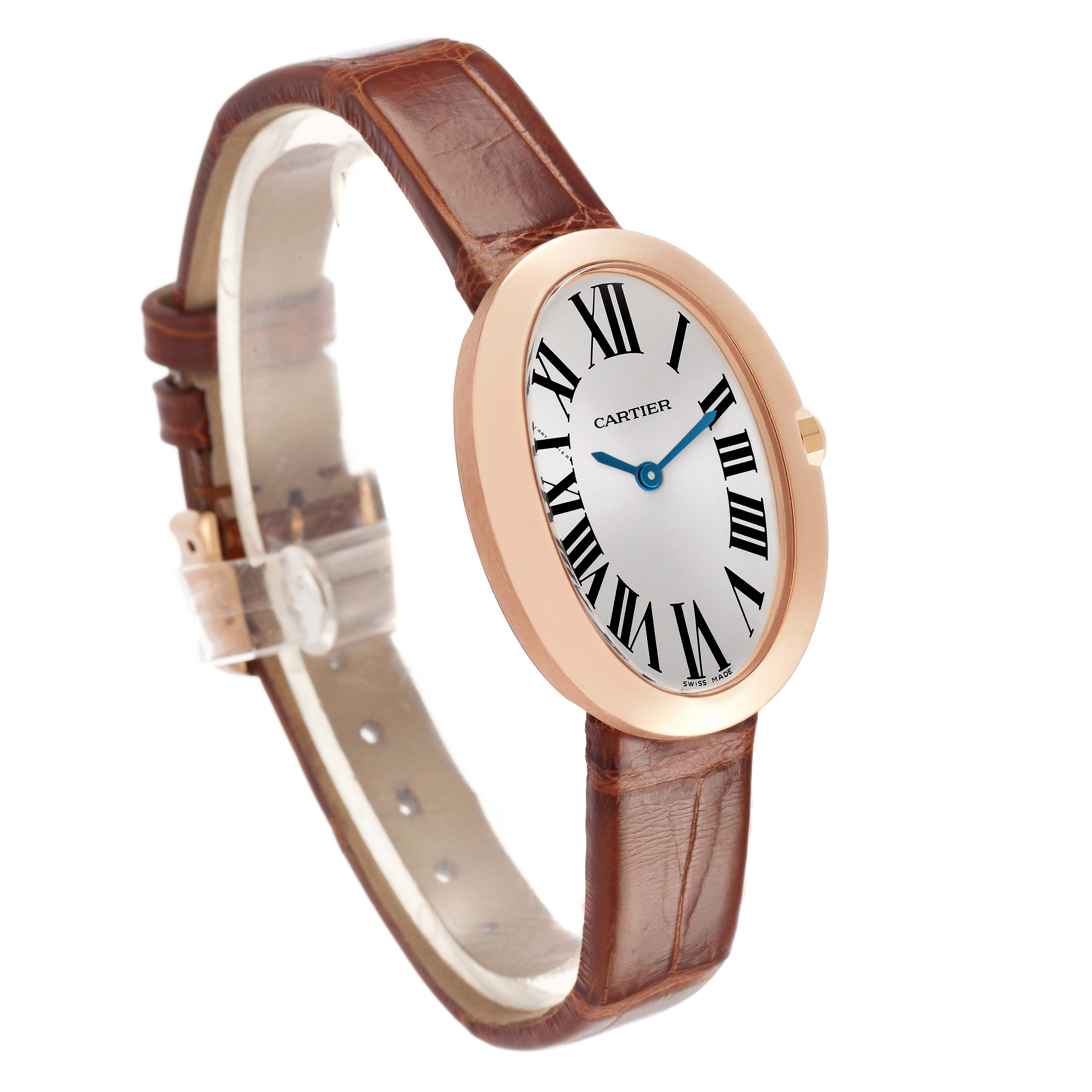 The Cartier Baignoire W8000007 Women's Rose Gold Silver Dial watch is shown from a front-left angle, highlighting its oval face, gold bezel, and brown leather strap.