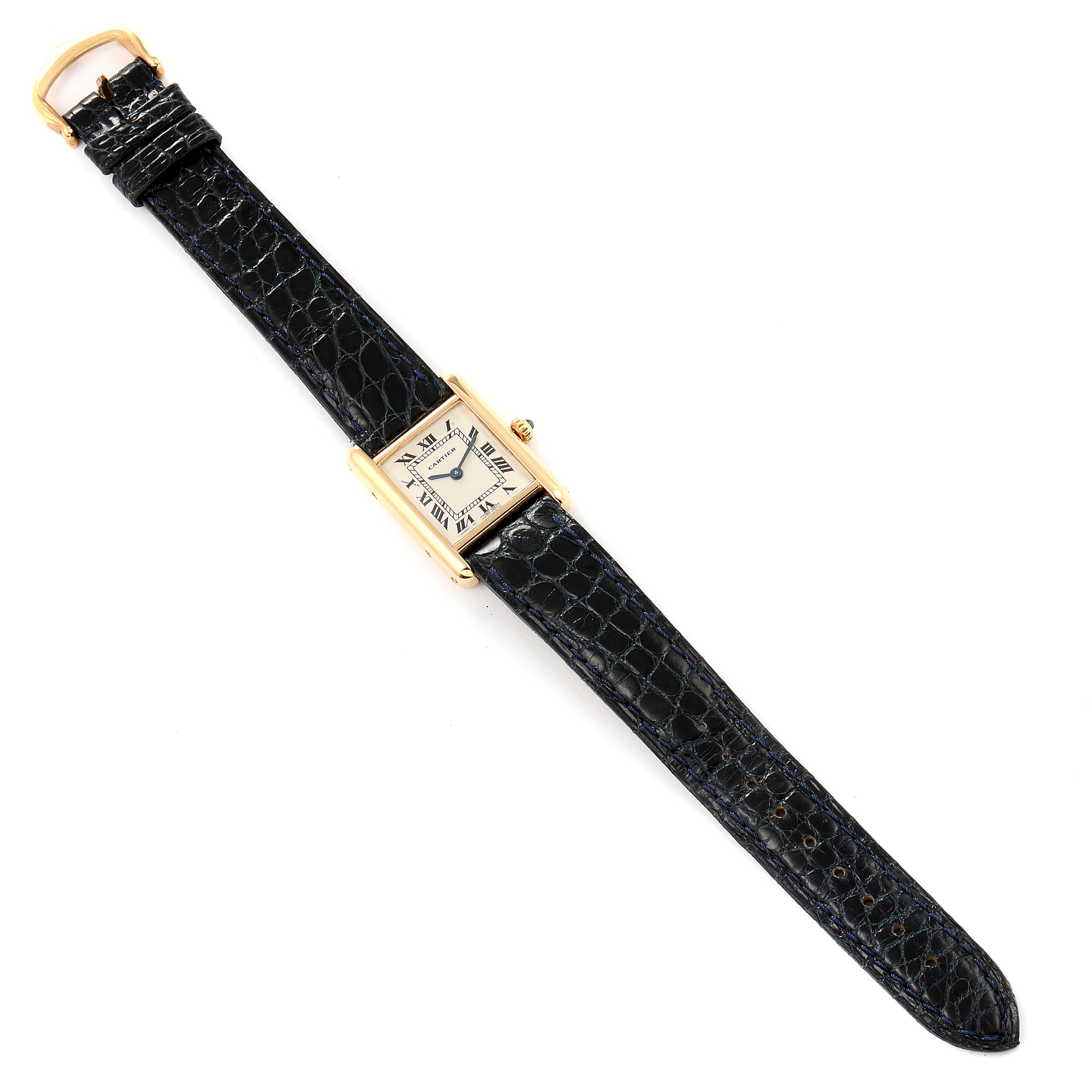 The image shows a top view of a Cartier Tank Classic Women's Yellow Gold White Dial Women's Yellow Gold White Dial watch with a black leather strap and gold-tone case.