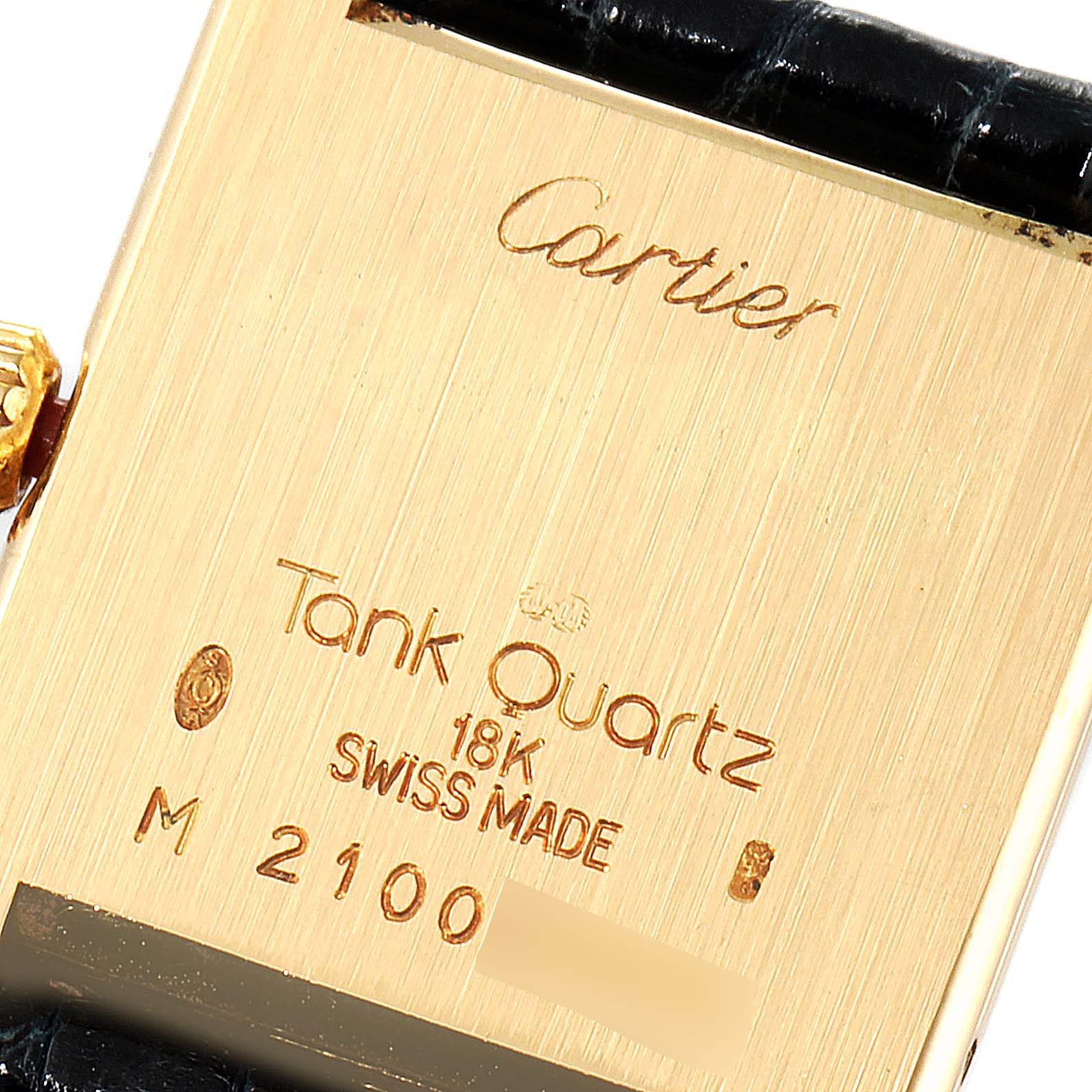 The image shows the back case of a Cartier Tank Classic Women's Yellow Gold White Dial Women's Yellow Gold White Dial watch, highlighting the engravings and leather strap attachment.