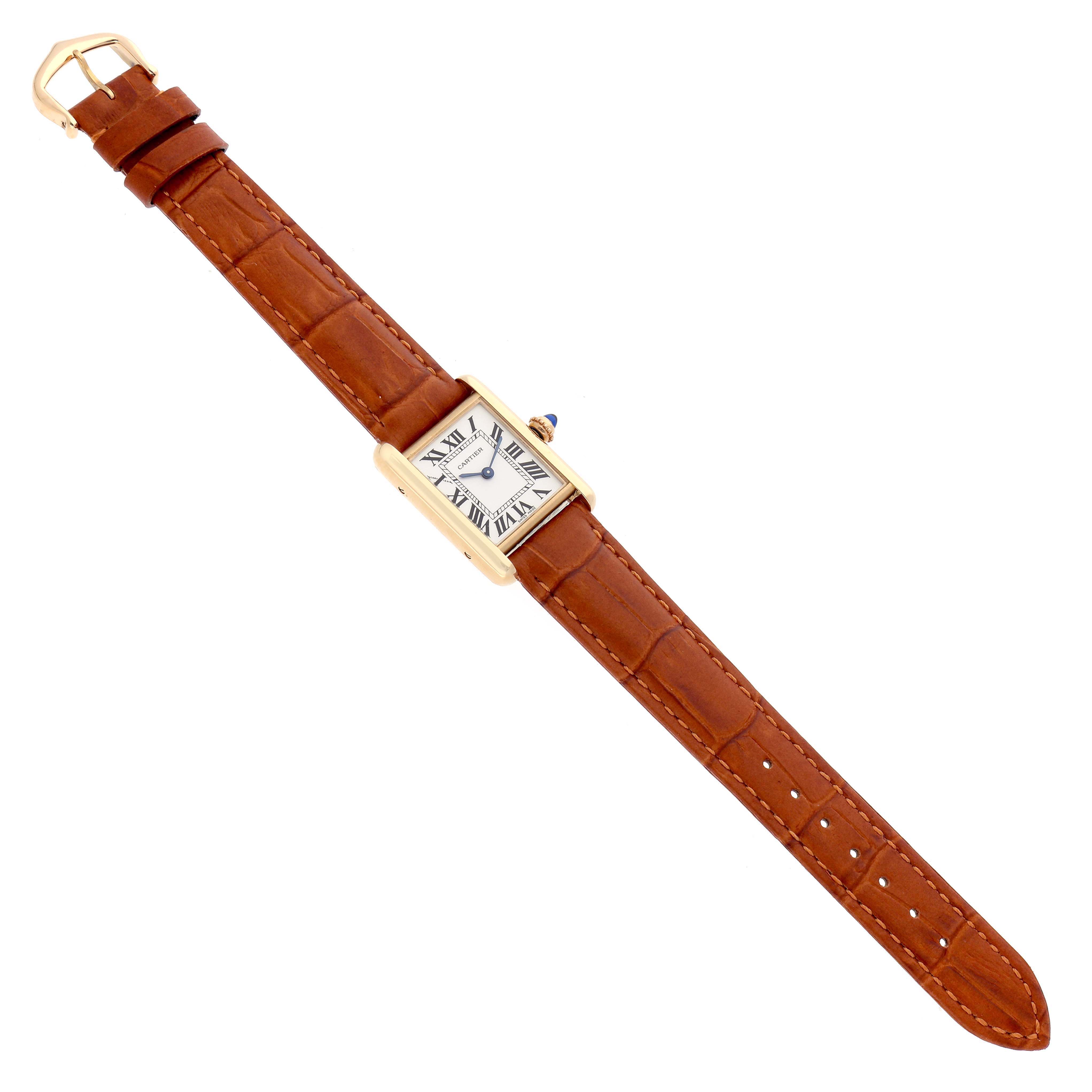 The Cartier Tank Louis W1529856 Women's Yellow Gold Silver Dial watch is shown from a top view, displaying its rectangular face, brown leather strap, and gold-tone casing.