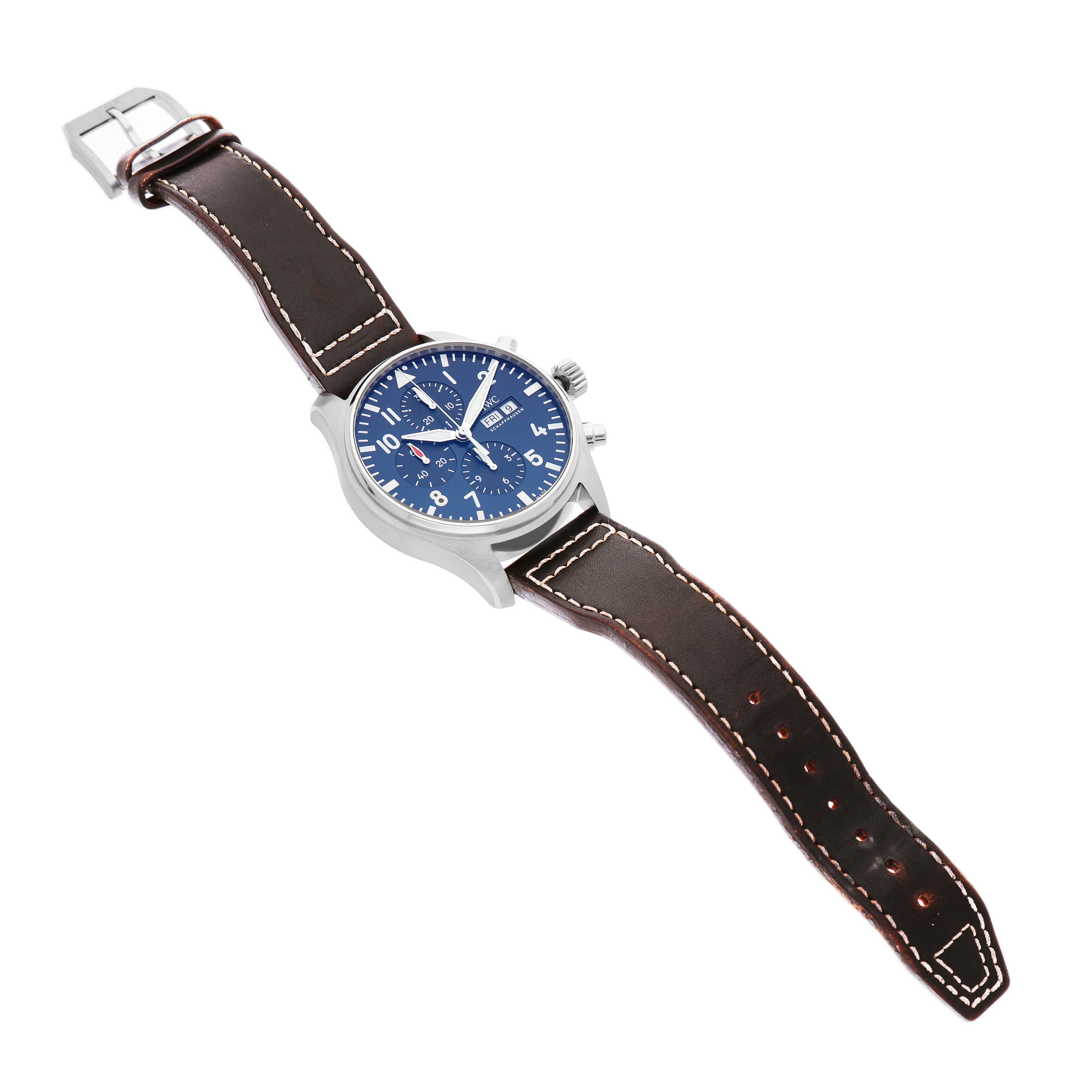 The IWC Pilot IW377714 Men's Stainless Steel Blue Dial watch is shown from an overhead angle, displaying the full face, case, and leather strap.