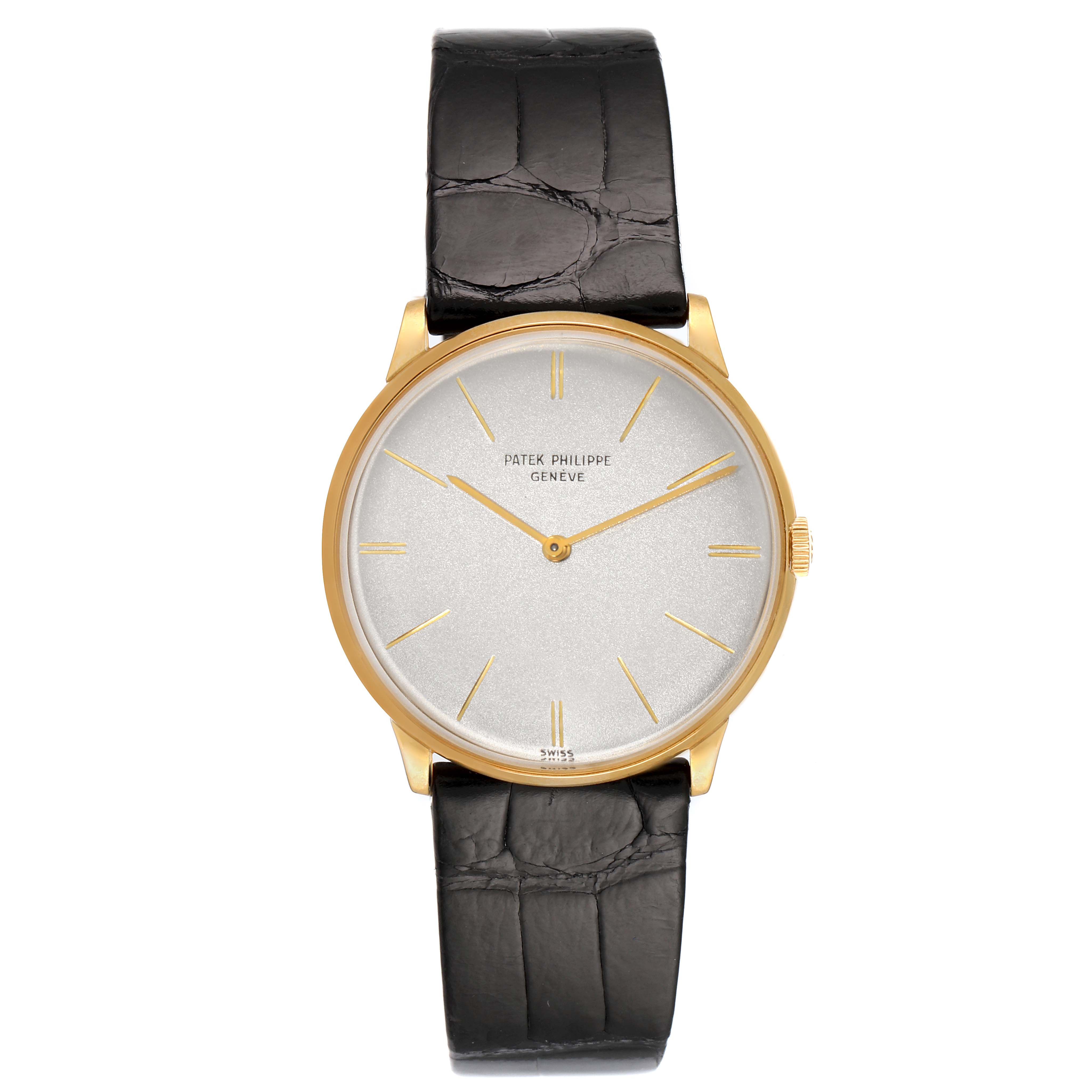 The Vintage Patek Philippe watch is shown from a top-down angle, displaying its face, leather strap, and gold casing.