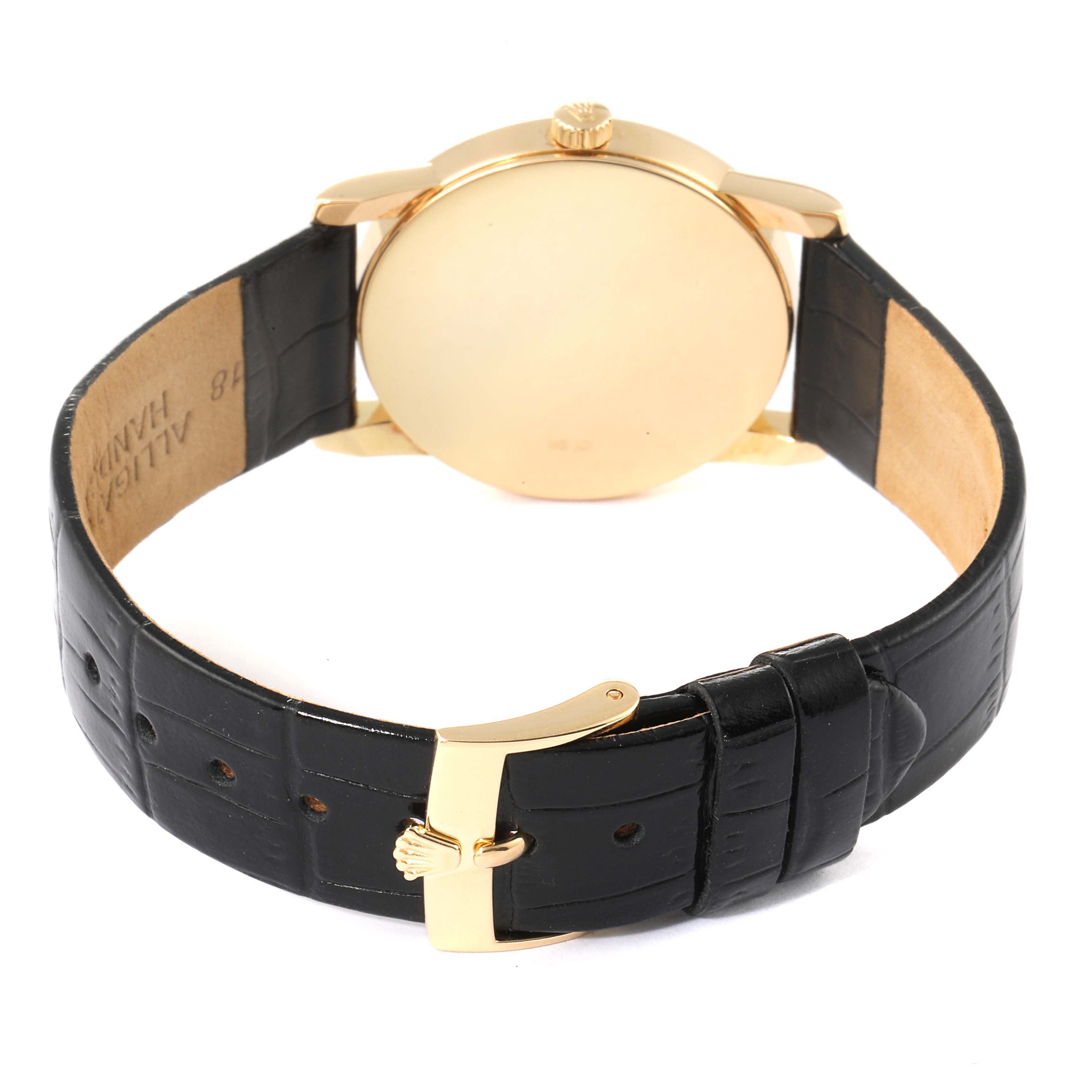 This image shows the back view of a Rolex Cellini 5116/8 Men's Yellow Gold Beige Dial 5116/8 Men's Yellow Gold Beige Dial watch, highlighting its gold case and black leather strap.