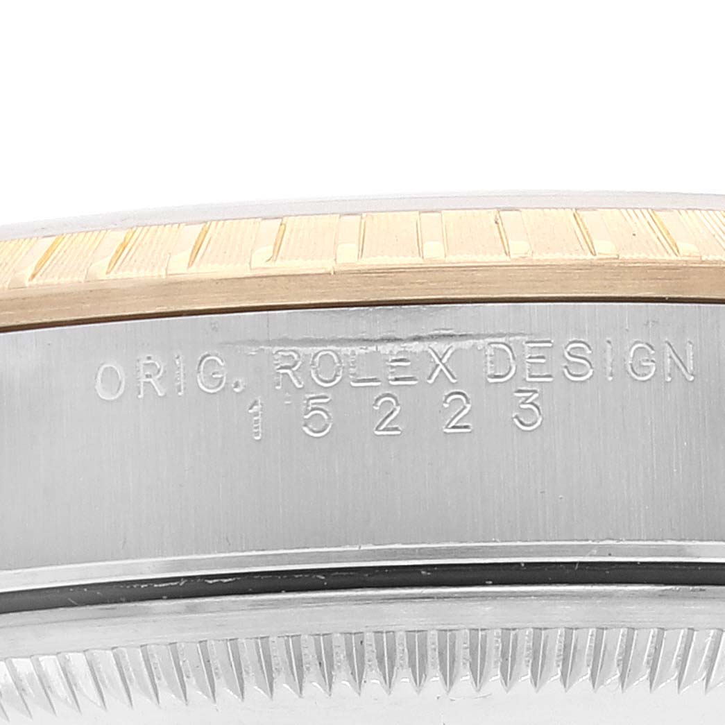 The image shows a side view of the case of a Rolex Date 15223 Men's Steel and Gold (two tone) Champagne Dial 15223 Men's Steel and Gold (two tone) Champagne Dial model, highlighting the bezel and the "ORIG. ROLEX DESIGN" engraving with the model number 15223.