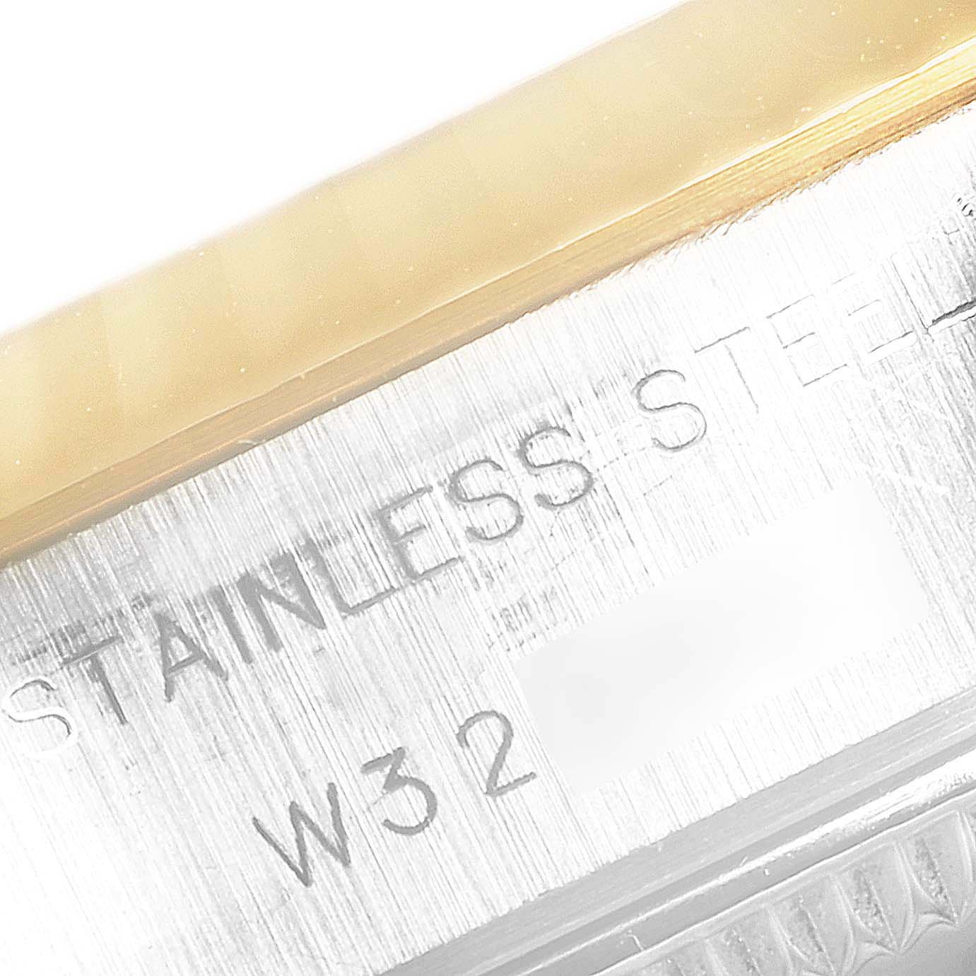 This image shows a close-up of the engraved stainless steel case of a Rolex Datejust 69173 Women's Stainless Steel Champagne Dial 69173 Women's Stainless Steel Champagne Dial watch.