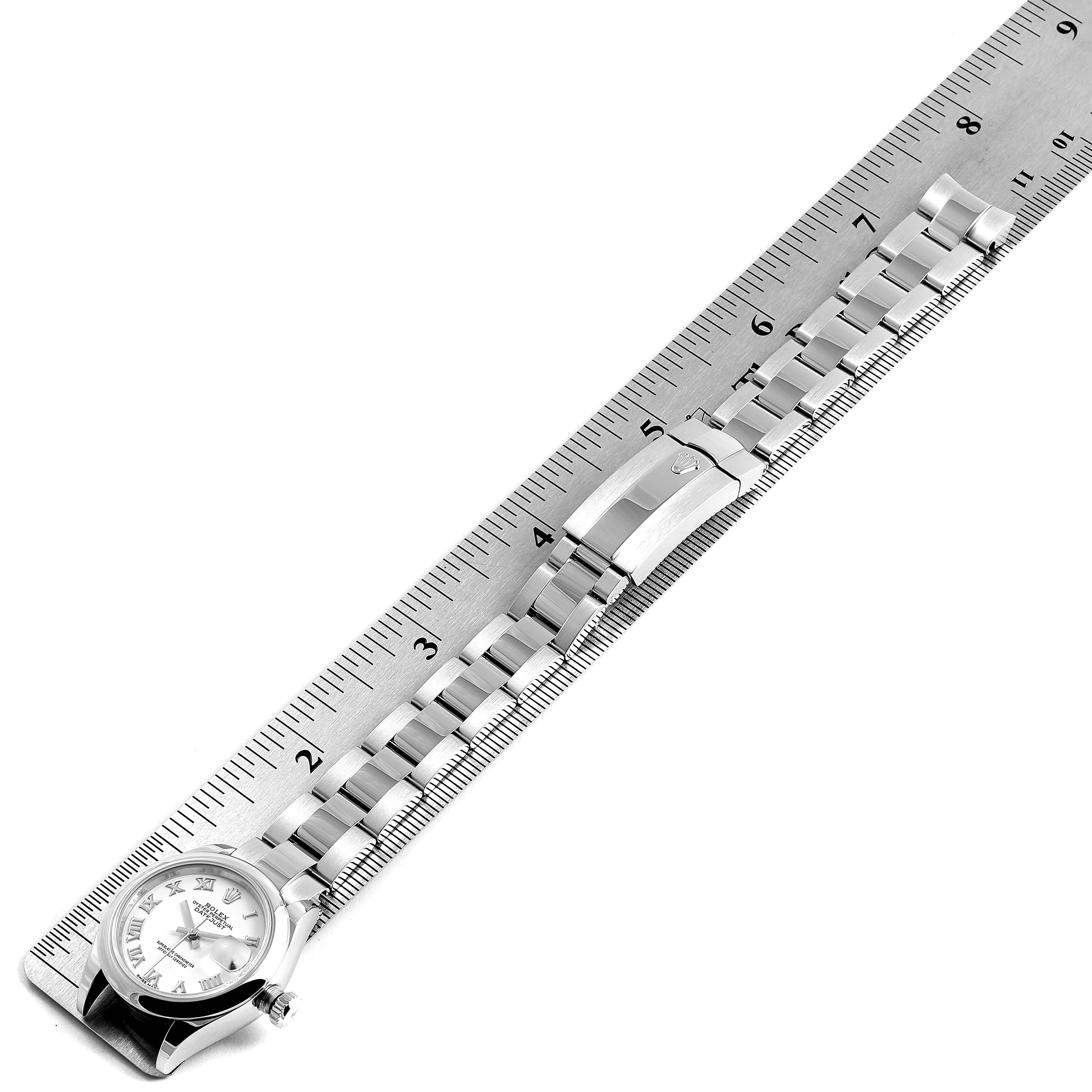 The image shows a Rolex Datejust 279160 Women
s Stainless Steel White Dial 279160 Women
s Stainless Steel White Dial watch face and bracelet band placed alongside a ruler for measurement.