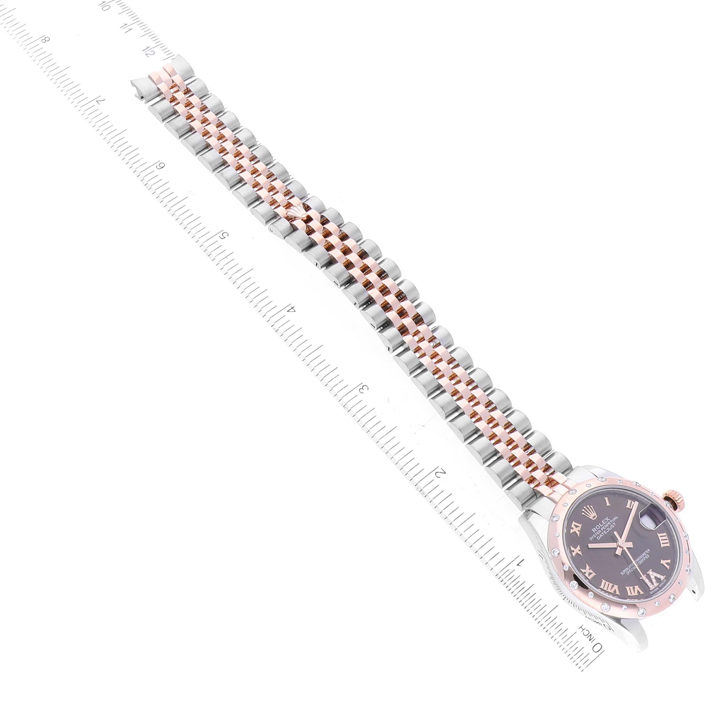 The image shows a Rolex Mid-Size 178341 Women's Stainless Steel Brown Dial 178341 Women's Stainless Steel Brown Dial watch lying flat, with a focus on its band, bezel, and face, alongside a ruler for size reference.