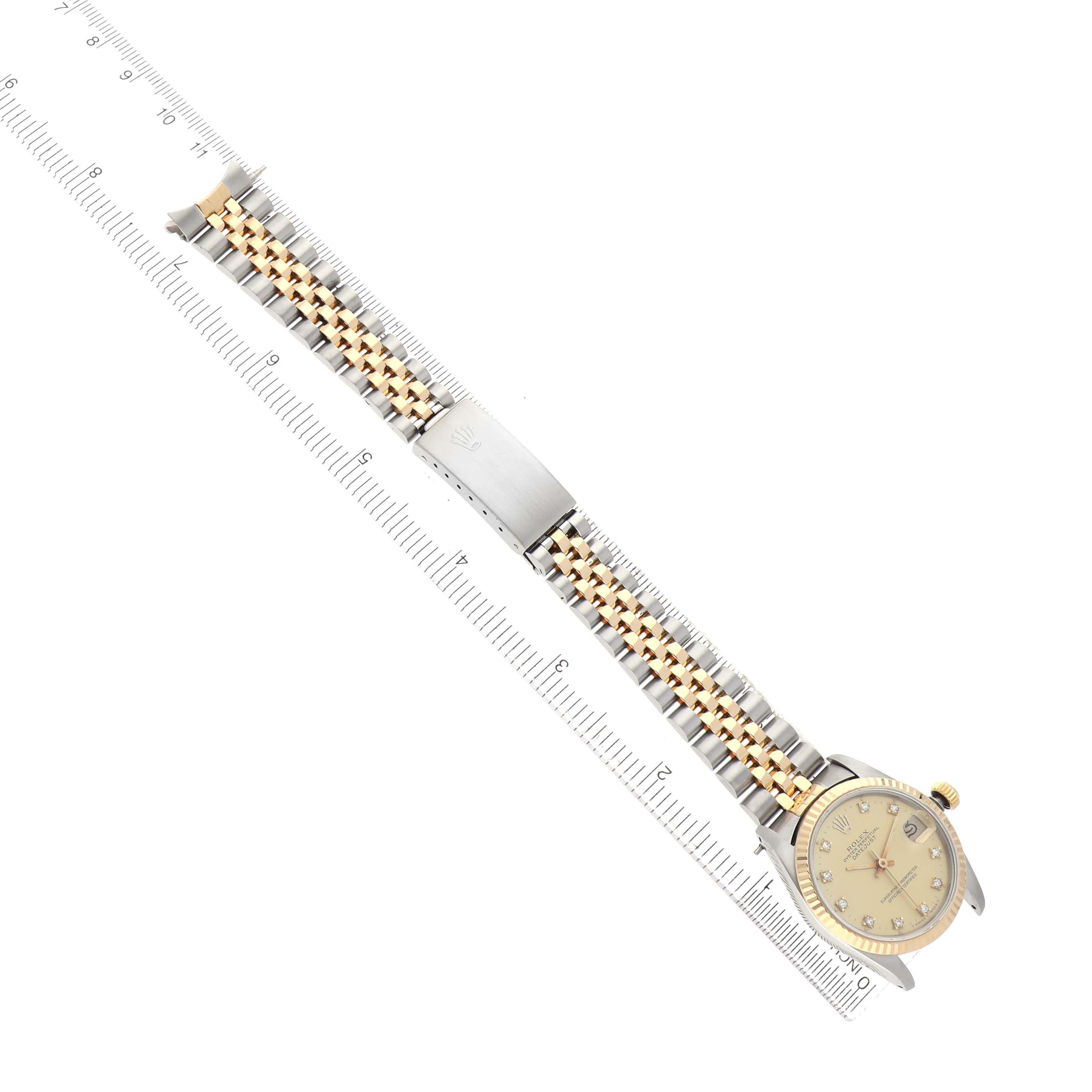 The Rolex Datejust 68273 Women's Stainless Steel Champagne Dial watch is shown from above, displaying the full bracelet and face, alongside a ruler for scale.