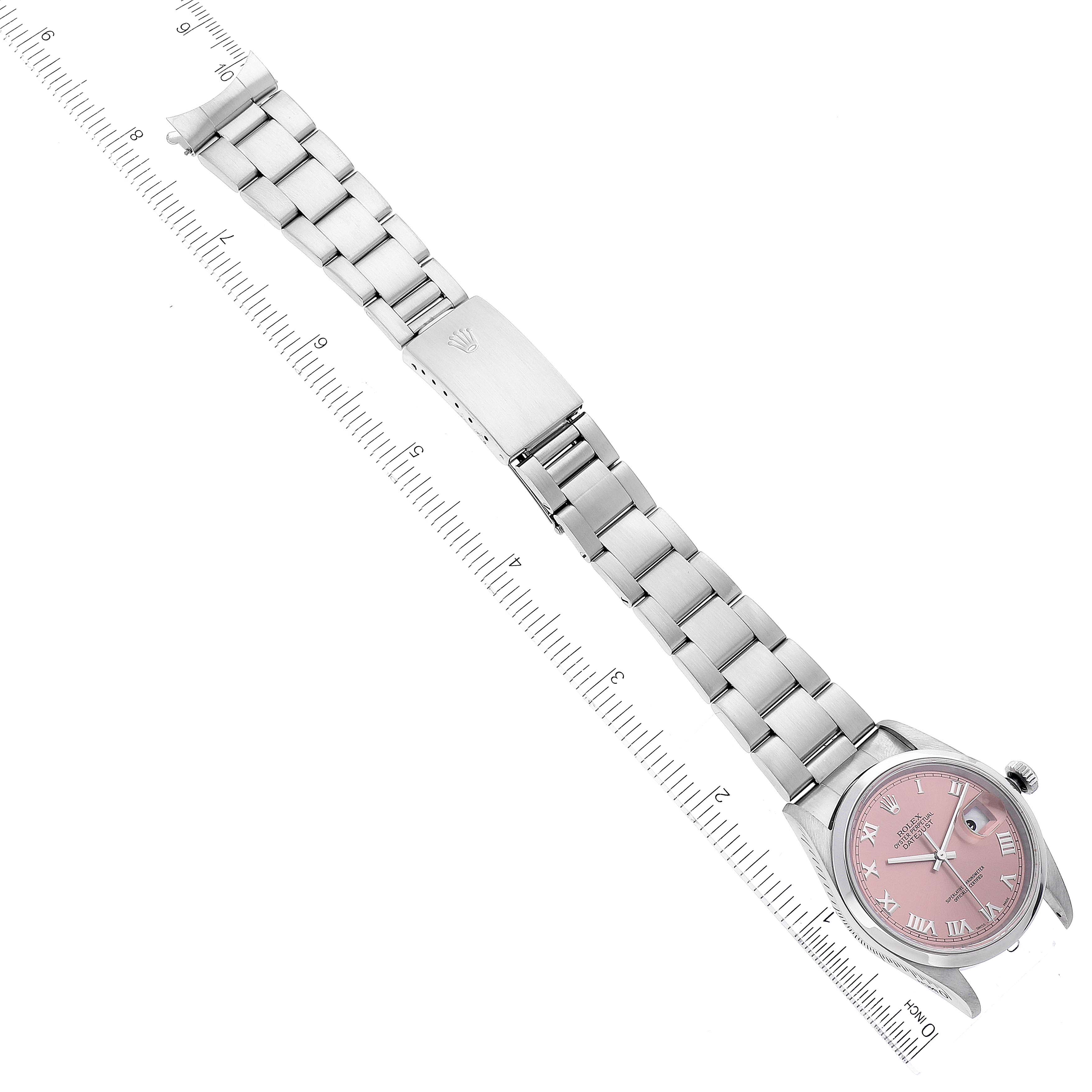 The image shows a full Rolex Datejust 16200 Men's Stainless Steel Pink Dial 16200 Men's Stainless Steel Pink Dial watch with a pink dial and stainless steel bracelet aligned next to a ruler.
