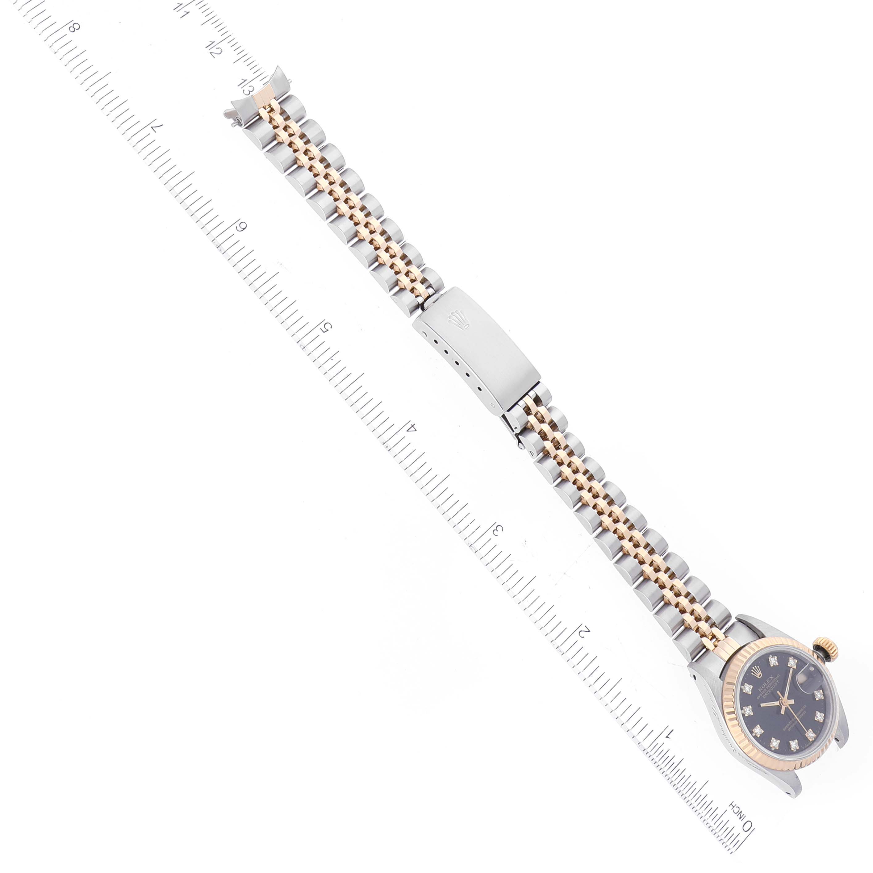 The image displays a Rolex Datejust 69173 Women's Steel and Gold (two tone) Black Dial 69173 Women's Steel and Gold (two tone) Black Dial watch laid flat, with the full bracelet and clasp visible alongside a ruler for scale.