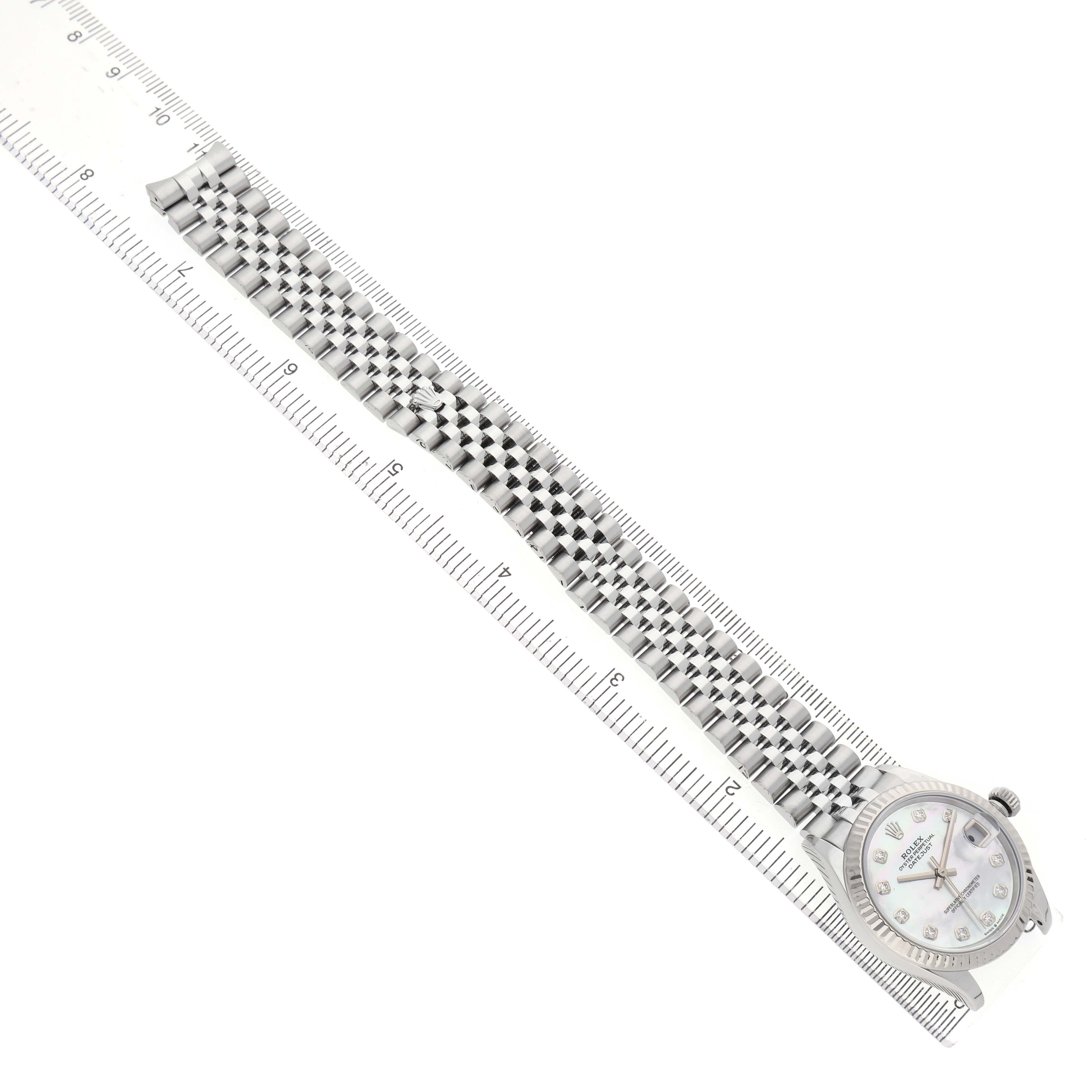The Rolex Mid-Size 278274 Women's Stainless Steel Mother of Pearl Dial watch is shown from a top-down angle, displaying the full bracelet alongside a ruler.