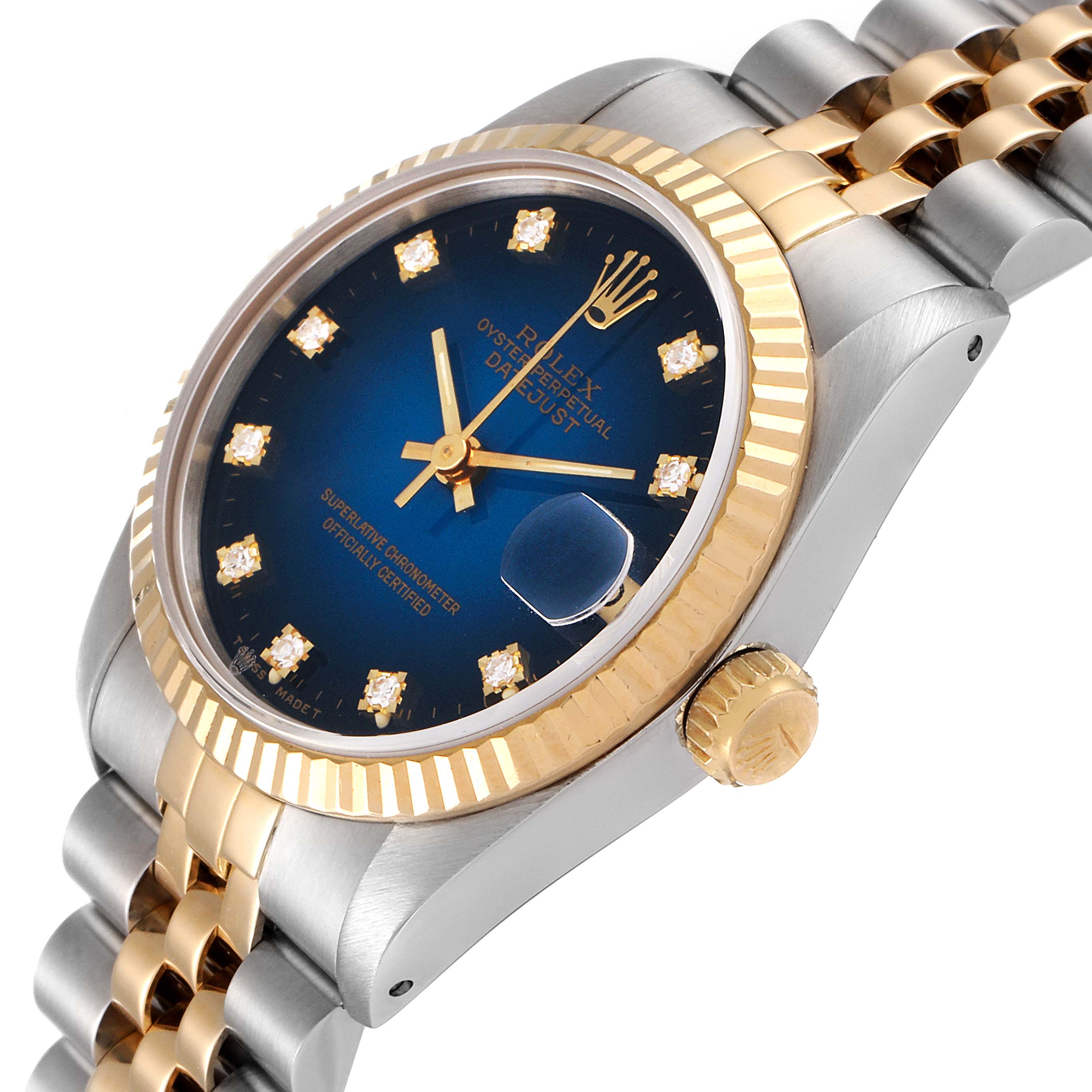 The Mid-Size Rolex watch is shown at an angle highlighting its blue dial, gold bezel, crown, bracelet, and diamond hour markers.