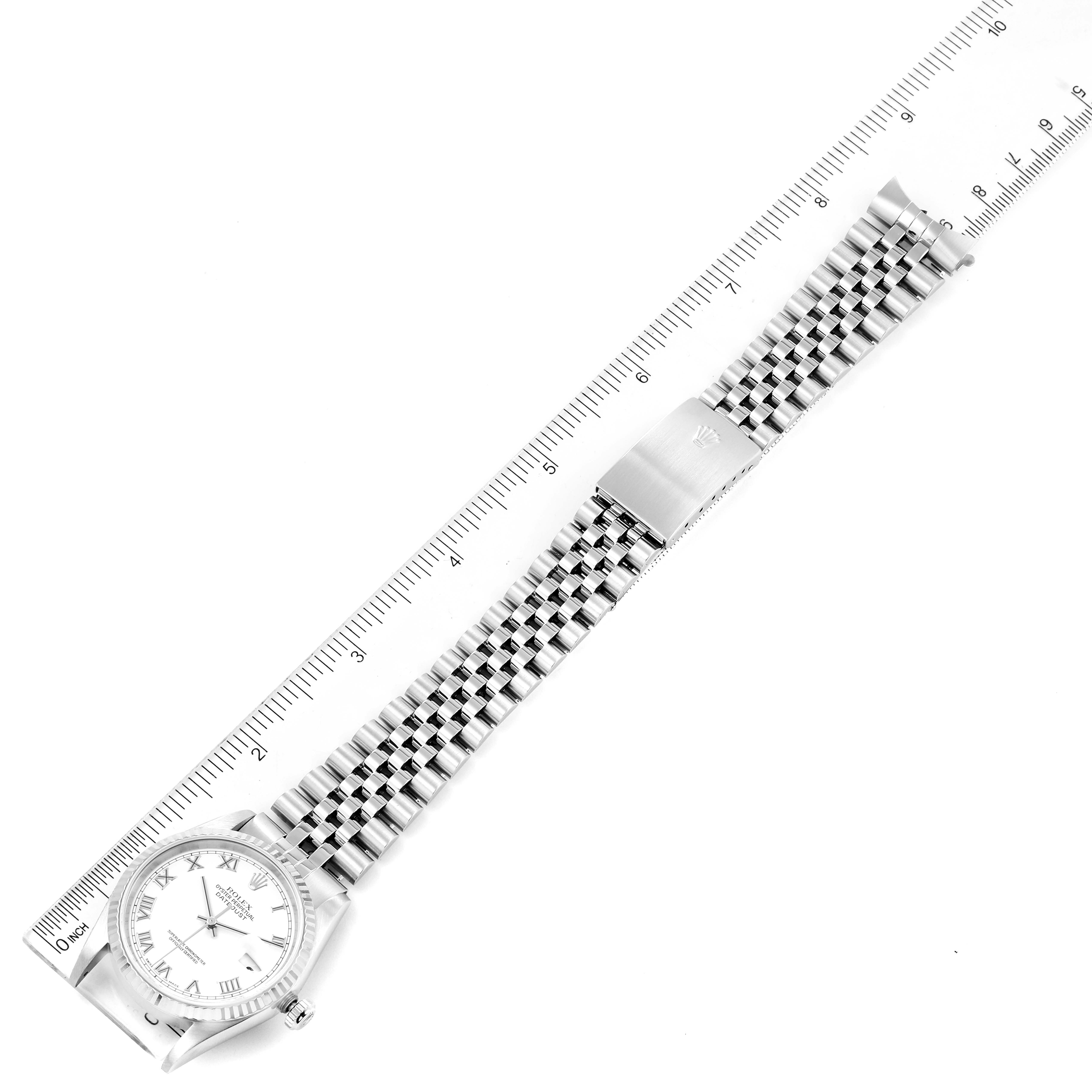 The image shows a top view of a Rolex Datejust 16234 Men's Stainless Steel White Dial 16234 Men's Stainless Steel White Dial watch with a metal bracelet alongside a ruler for scale.